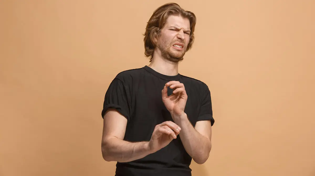 Ew. It's so gross. Young man with disgusted expression repulsing something. Disgust concept. Young emotional man. Human emotions, facial expression concept. Studio. Isolated on trendy pastel color