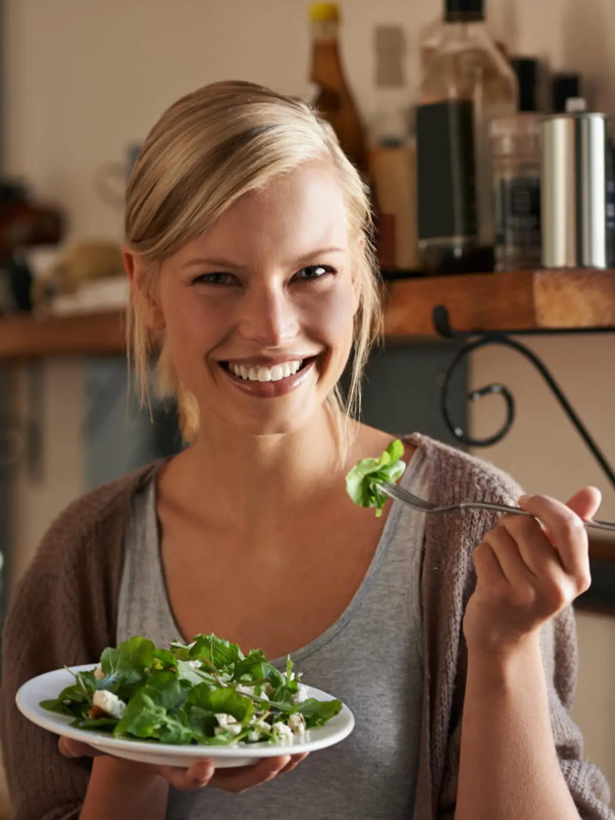 Portrait of an attractive young woman eating a salad in her kitchen