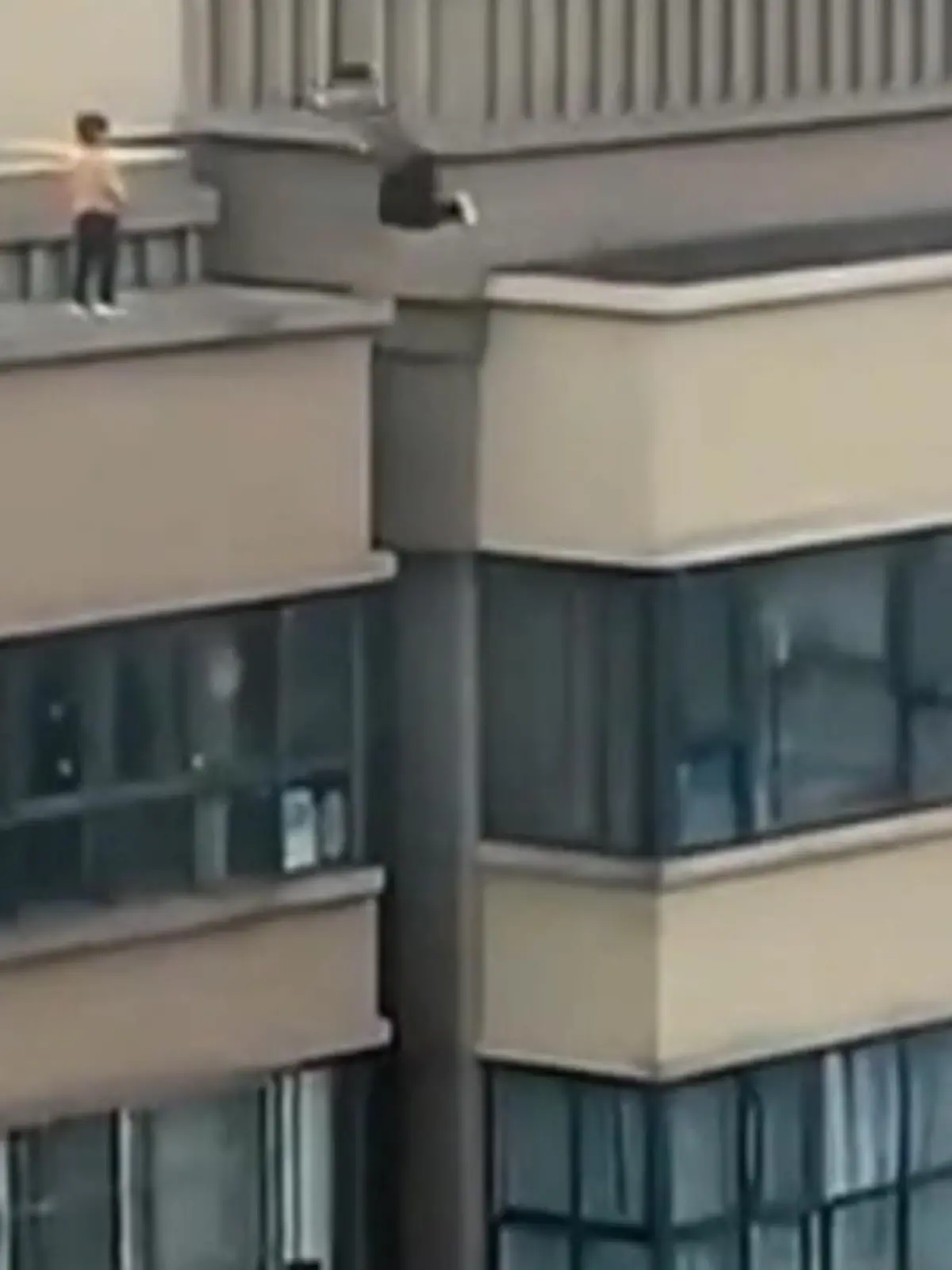 Zwei kleine Jungen springen in schwindelerregender Höhe auf einem Hochhausdach herum. Von einem gegenüberliegenden Haus filmt ein Anwohner die dramatischen Szenen.