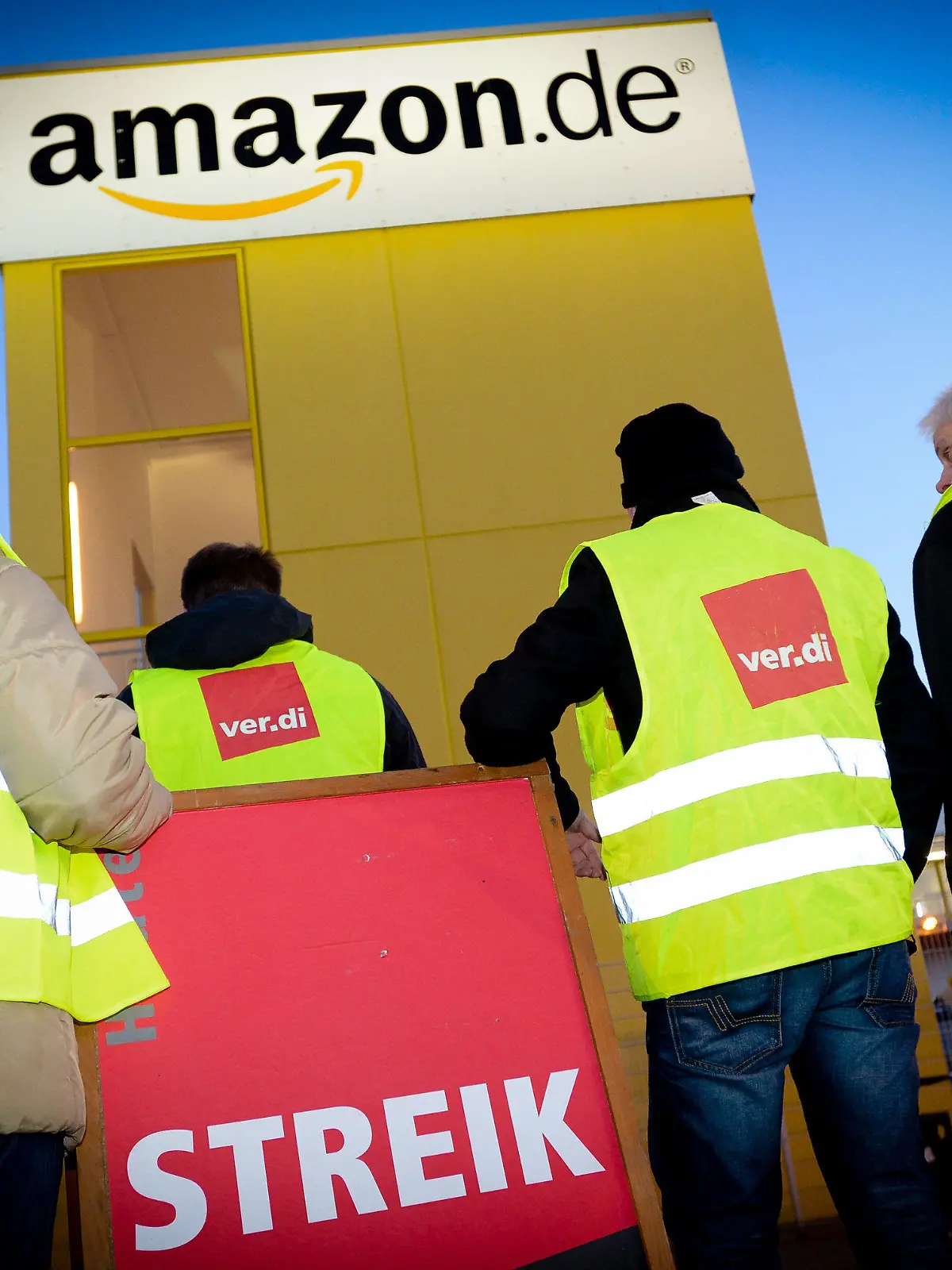 ARCHIV - Streikende Mitarbeiter stehen vor der Betriebsstätte des Online-Händlers Amazon am 08.12.2014 in Leipzig (Sachsen). Mitten im Weihnachtsgeschäft rief die Gewerkschaft Verdi auch die Beschäftigten der Spätschicht in Leipzig zum Streik auf. Foto: Peter Endig/dpa (zu lsn vom 20.12.2014) +++(c) dpa - Bildfunk+++