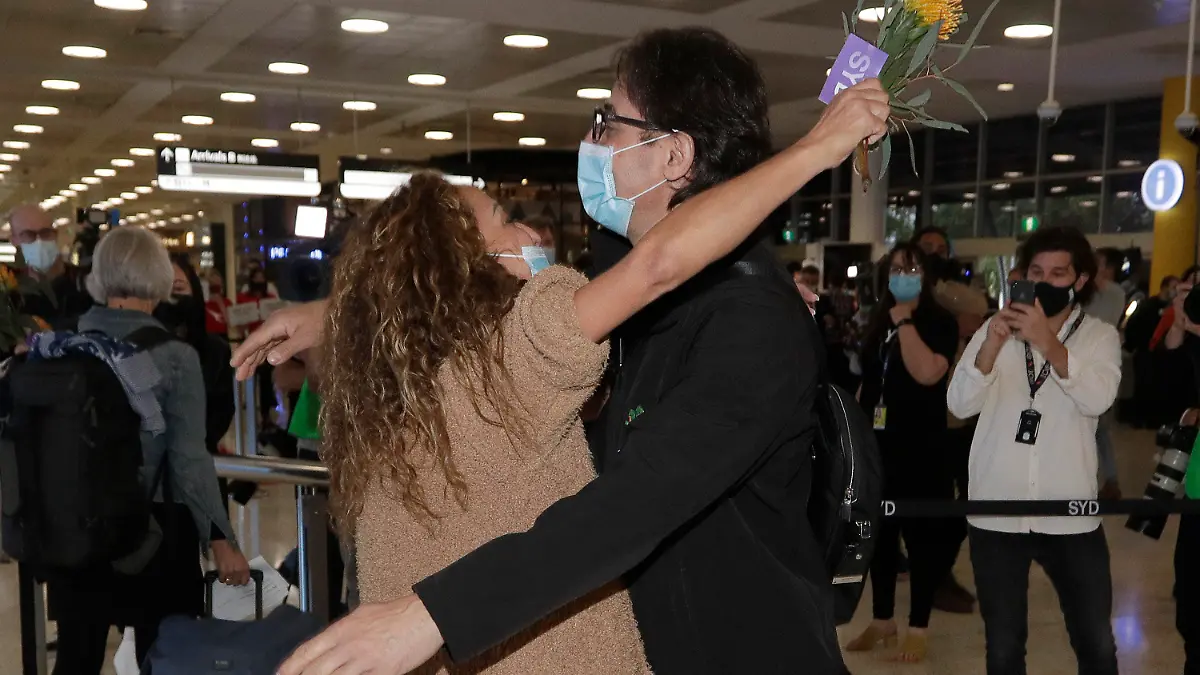 31.10.2021, Australien, Sydney: Eine Frau (l) wird von ihrem Bruder umarmt, nachdem sie mit einem Flug aus Los Angeles am Flughafen von Sydney angekommen ist, als Australien am Montag, 1. November 2021, zum ersten Mal seit 19 Monaten seine Grenzen öffnet. Der internationale Reiseverkehr wird zunächst auf den Flughafen von Sydney beschränkt sein, da New South Wales die höchste Impfrate aller Bundesstaaten aufweist. Foto: Rick Rycroft/AP/dpa +++ dpa-Bildfunk +++
