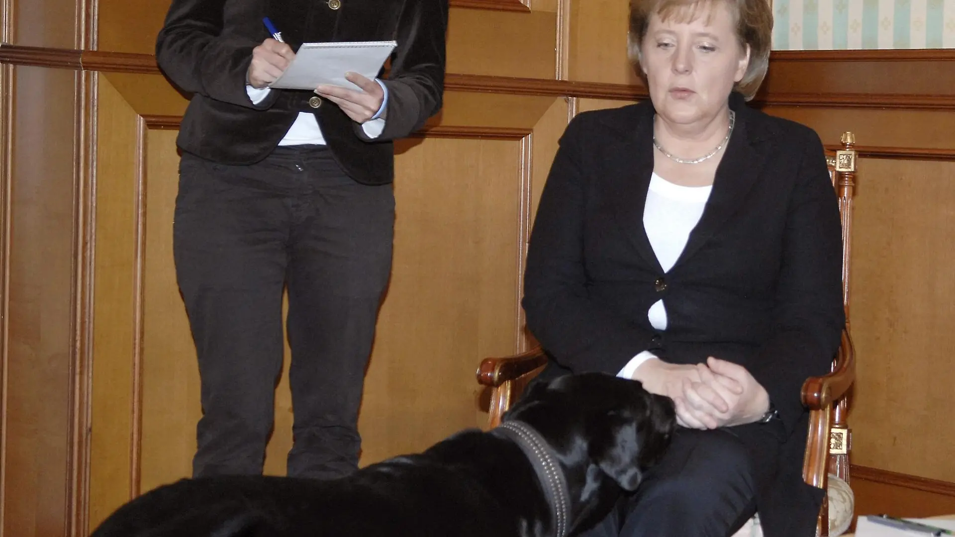 Bundeskanzlerin Angela Merkel wird im Jahr 2007 in der Residenz des russischen Präsidenten Putin in Sotschi von dessen Hund beschnuppert.