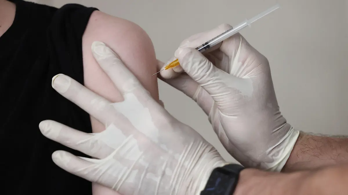 ARCHIV - 08.06.2021, Nordrhein-Westfalen, Köln: Der Hausarzt Tim Koop impft in seiner Praxis einen Jugendlichen mit dem Serum von Biontech/Pfizer. Die Biontech/Pfizer-Impfung senkt laut einer Studie das Risiko einer Infektion mit der Delta-Variante des Corona-Virus bei Jugendlichen um 90 Prozent. (zu dpa «Studie: Corona-Impfung von Jugendlichen zu 90 Prozent effektiv») Foto: Oliver Berg/dpa +++ dpa-Bildfunk +++