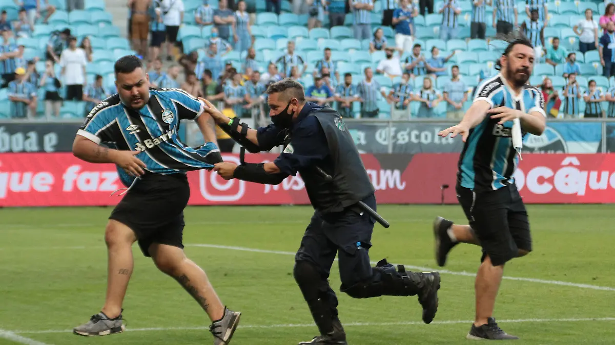 PORTO ALEGRE, BRAZIL - OCTOBER 31: Fans of Gremio invade the field during the match between Gremio and Palmeiras as part of Brasileirao Series A 2021 at Arena do Gremio Stadium on October 31, 2021, in Porto Alegre, Brazil.  (Photo by Silvio Avila/Getty Images)