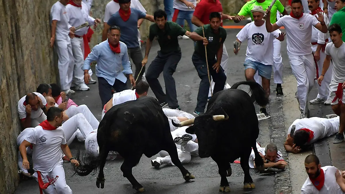 07.07.2018, Spanien, Pamplona: Teilnehmer der Stierhatz treiben zwei Stiere durch die Gassen von Pamplona. Bis zum 14. Juli werden während des «Sanfermines»-Festes täglich am frühen Vormittag Kampfbullen und Leitochsen von Hunderten von Männern und wenigen Frauen, für die Stierkämpfe am Abend, durch die Gassen in die Arena gejagt. Foto: Alvaro Barrientos/AP/dpa +++ dpa-Bildfunk +++
