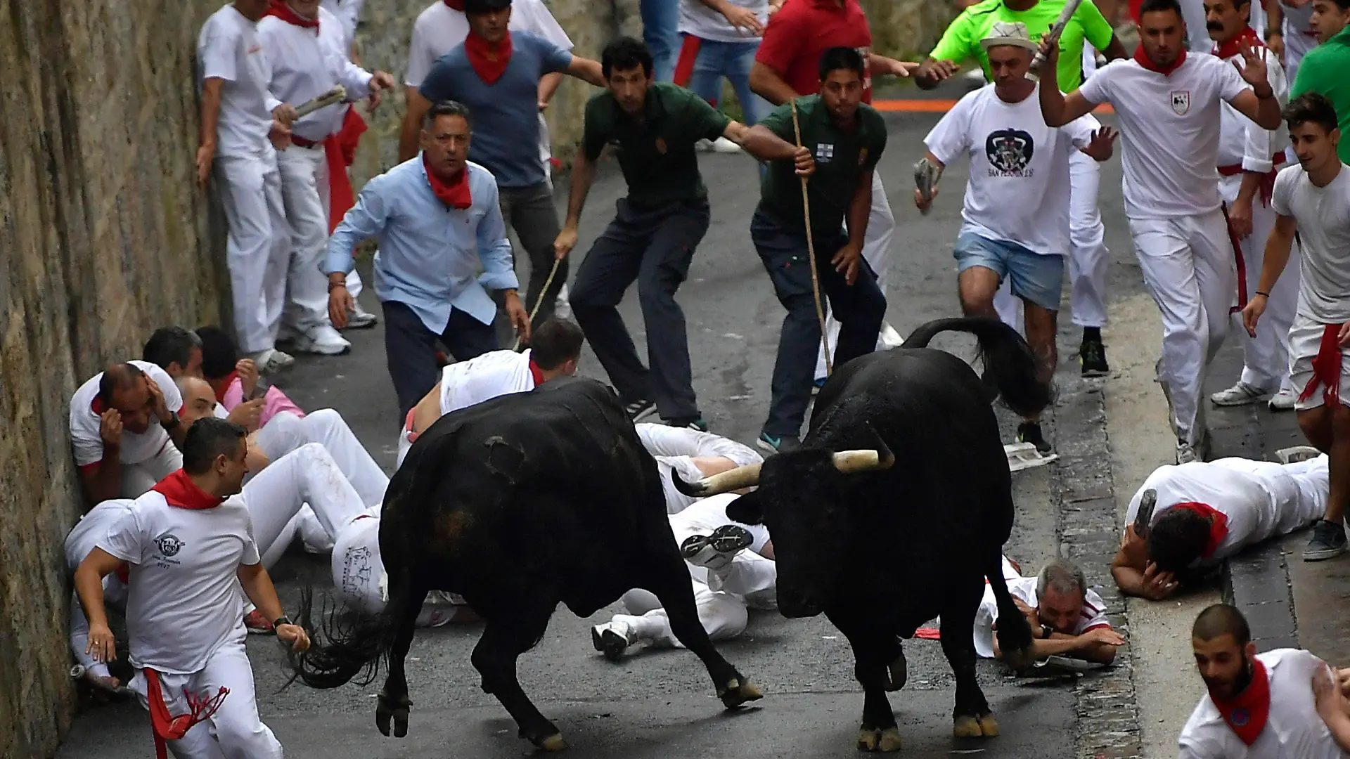 07.07.2018, Spanien, Pamplona: Teilnehmer der Stierhatz treiben zwei Stiere durch die Gassen von Pamplona. Bis zum 14. Juli werden während des «Sanfermines»-Festes täglich am frühen Vormittag Kampfbullen und Leitochsen von Hunderten von Männern und wenigen Frauen, für die Stierkämpfe am Abend, durch die Gassen in die Arena gejagt. Foto: Alvaro Barrientos/AP/dpa +++ dpa-Bildfunk +++