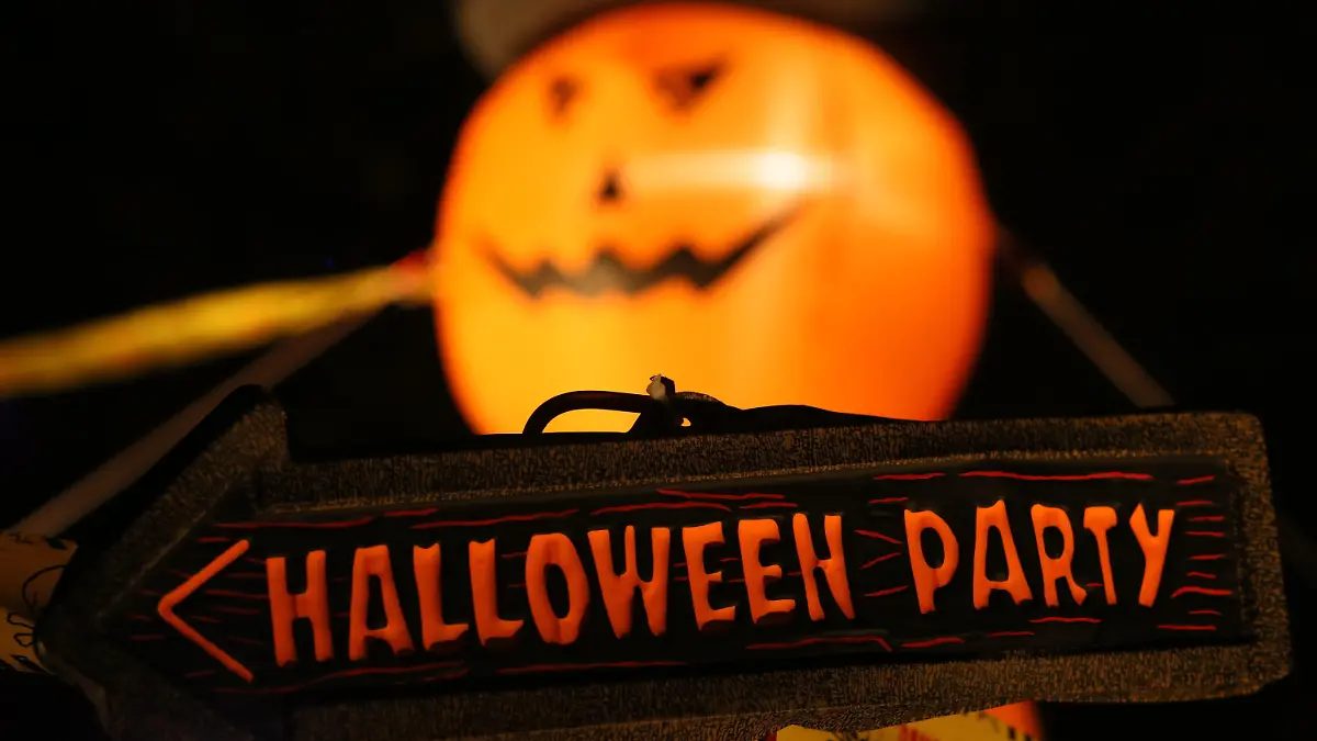 29.10.2021, Sachsen-Anhalt, Thale: Der Wegweiser "Halloween Party" steht vor einem zu einem Gesicht geschnitzten Kürbis im Kurpark der Stadt Thale. Hier wird auch in diesem Jahr in eingeschränkter Version das Halloween-Festival Hexoween bis Sonntag 31.10.2021 veranstaltet. Es präsentieren sich Händler und Schausteller. Foto: Matthias Bein/dpa-Zentralbild/dpa +++ dpa-Bildfunk +++