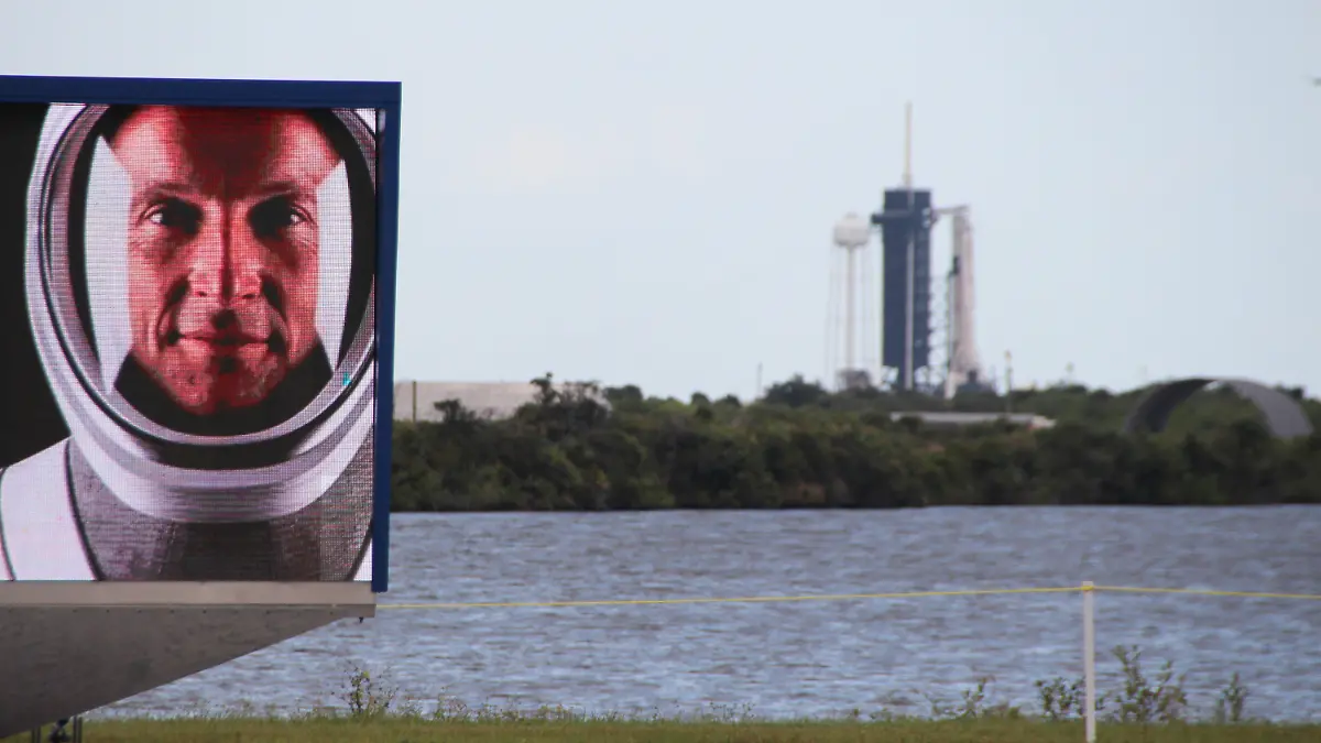 29.10.2021, USA, Cape Canaveral: Ein Video-Bildschirm zeigt die Gesichter der vier Astronauten der Crew-3 mit dem Deutschen Matthias Maurer vor dem Launchpad 39A, an dem schon die Falcon-9-Rakete mit Crew Dragon-Kapsel aufgestellt ist. (zum am 31.10. geplanten Start des deutschen Astronauten Matthias Maurer zur Internationalen Raumstation ISS) Foto: Christina Horsten/dpa +++ dpa-Bildfunk +++