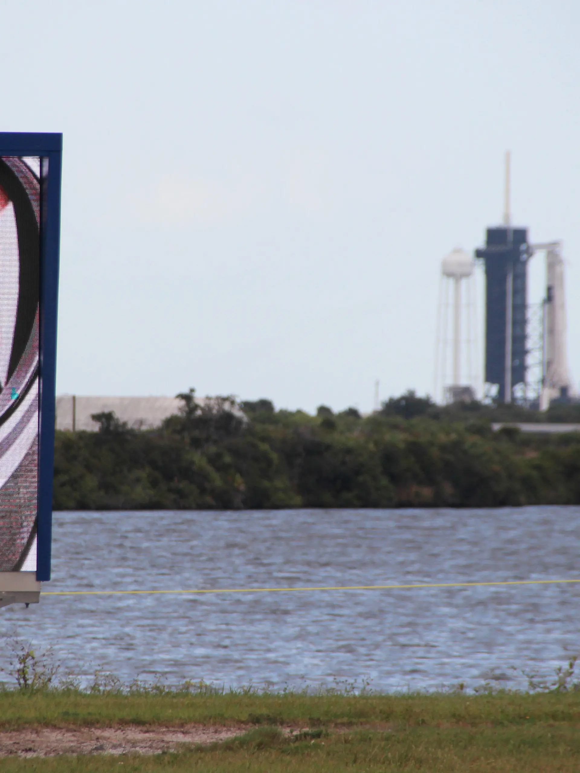 29.10.2021, USA, Cape Canaveral: Ein Video-Bildschirm zeigt die Gesichter der vier Astronauten der Crew-3 mit dem Deutschen Matthias Maurer vor dem Launchpad 39A, an dem schon die Falcon-9-Rakete mit Crew Dragon-Kapsel aufgestellt ist. (zum am 31.10. geplanten Start des deutschen Astronauten Matthias Maurer zur Internationalen Raumstation ISS) Foto: Christina Horsten/dpa +++ dpa-Bildfunk +++