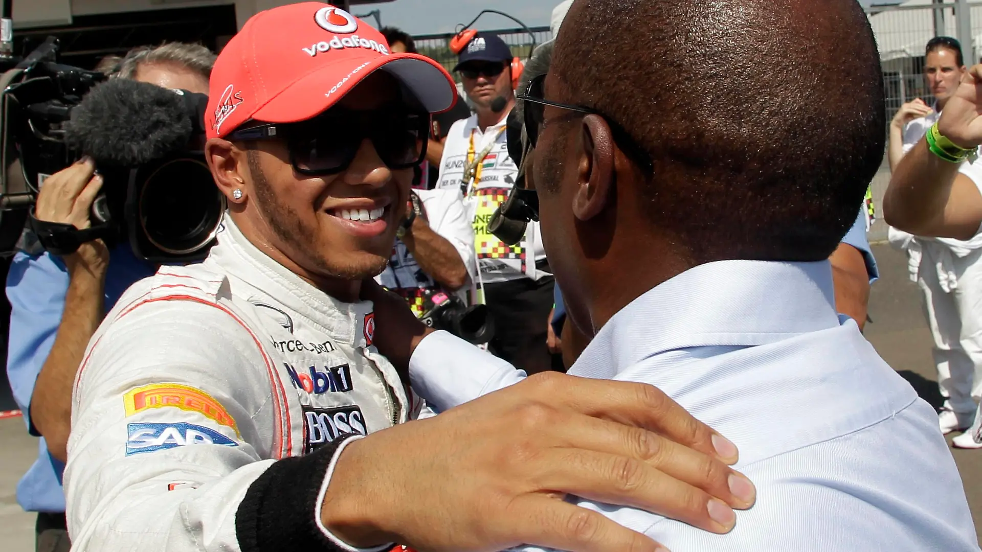 McLaren Formula One driver Lewis Hamilton of Britain hugs his father Anthony (R) after taking pole position during the qualifying session for the Hungarian Grand Prix at the Hungaroring circuit near Budapest July 28, 2012.    REUTERS/Leonhard Foeger  (HUNGARY - Tags: SPORT MOTORSPORT F1)