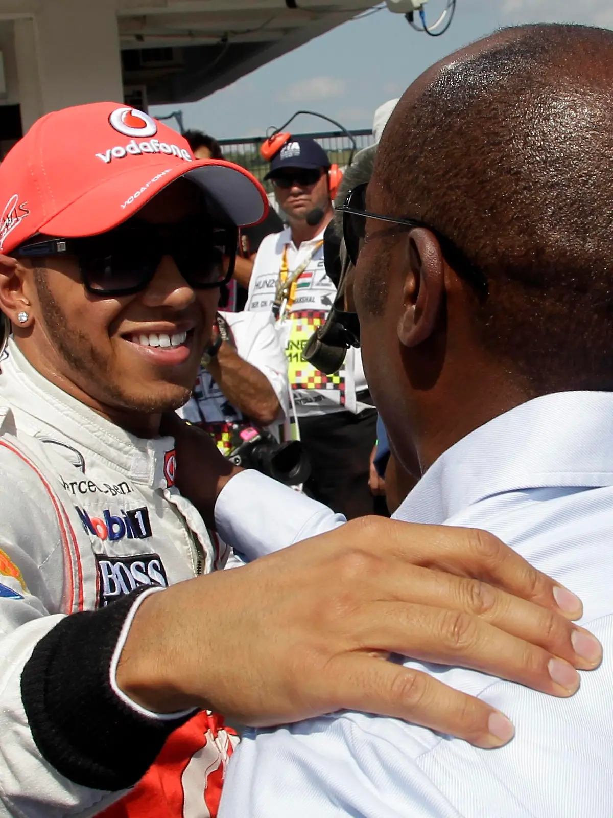 McLaren Formula One driver Lewis Hamilton of Britain hugs his father Anthony (R) after taking pole position during the qualifying session for the Hungarian Grand Prix at the Hungaroring circuit near Budapest July 28, 2012.    REUTERS/Leonhard Foeger  (HUNGARY - Tags: SPORT MOTORSPORT F1)