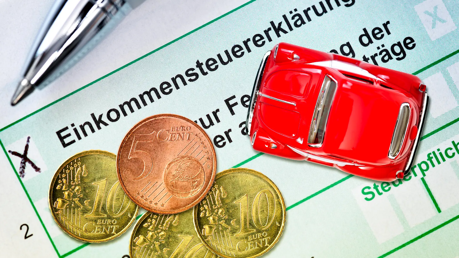 FOTOMONTAGE, Miniaturauto mit Geldmünzen auf Steuererklärung, Symbolfoto Pendlerpauschale 35 Cent ab 21 Km PHOTOMONTAGE, miniature car with coins on tax return, symbol photo commuter lump sum 35 cent from 21 km