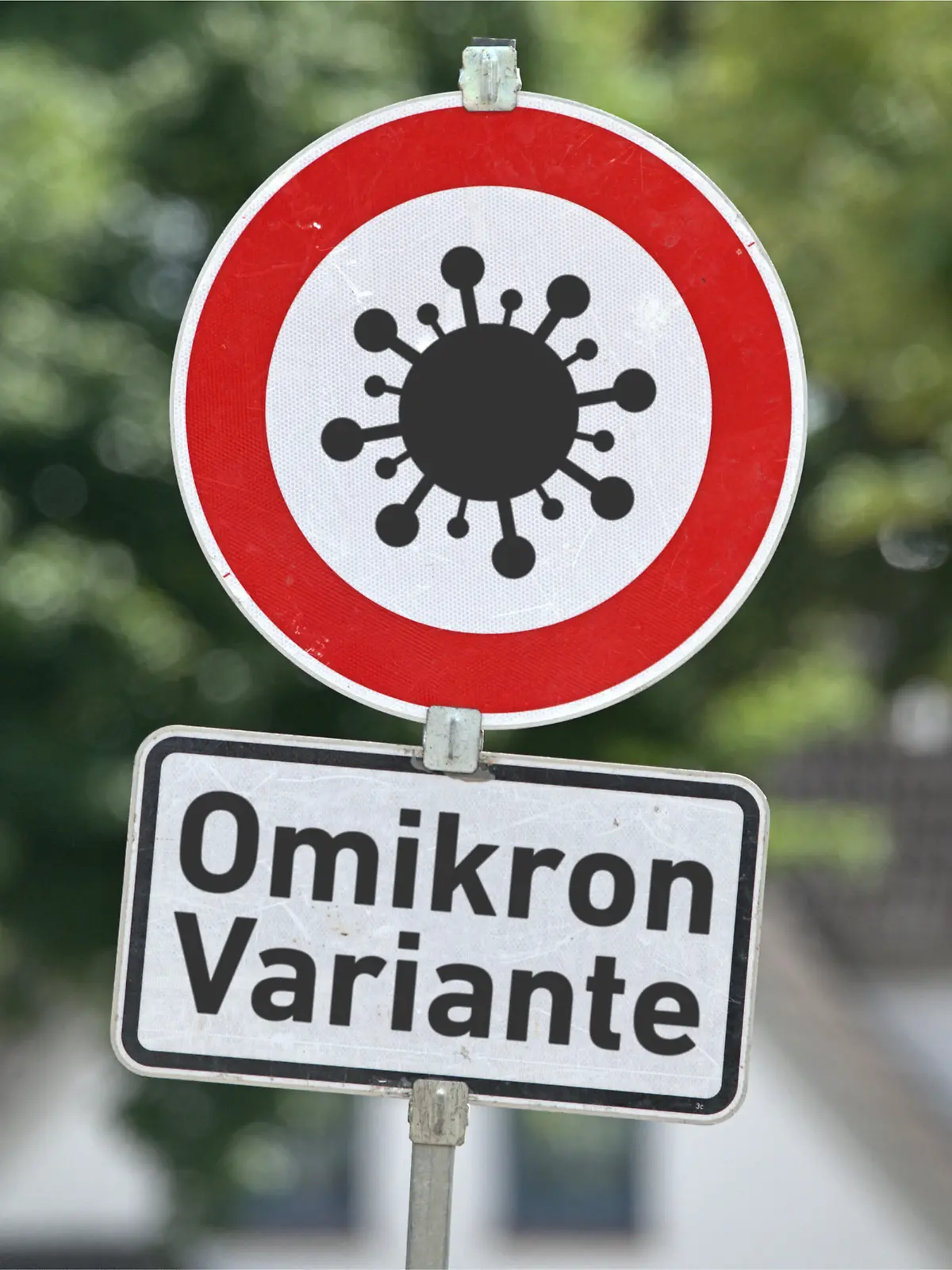 [M] Verkehrszeichen 274-xxx, für eine Warnung zur neuen Omikron-Variante des Corona-Virus in runder Form mit einem Corona-Piktogramm sowie ein Zusatzschild mit der Aufschrift: "Omikron Variante" an einem Schildermast. Foto mit Composing als Symbolbild für die neue Corona-Varante Omikron mit der wissenschaftlichen Bezeichnung B.1.1.529. B.1.1.529 weist eine sehr hohe Anzahl von Mutationen auf. +++ KEIN ECHTES VERKEHRSSCHILD +++