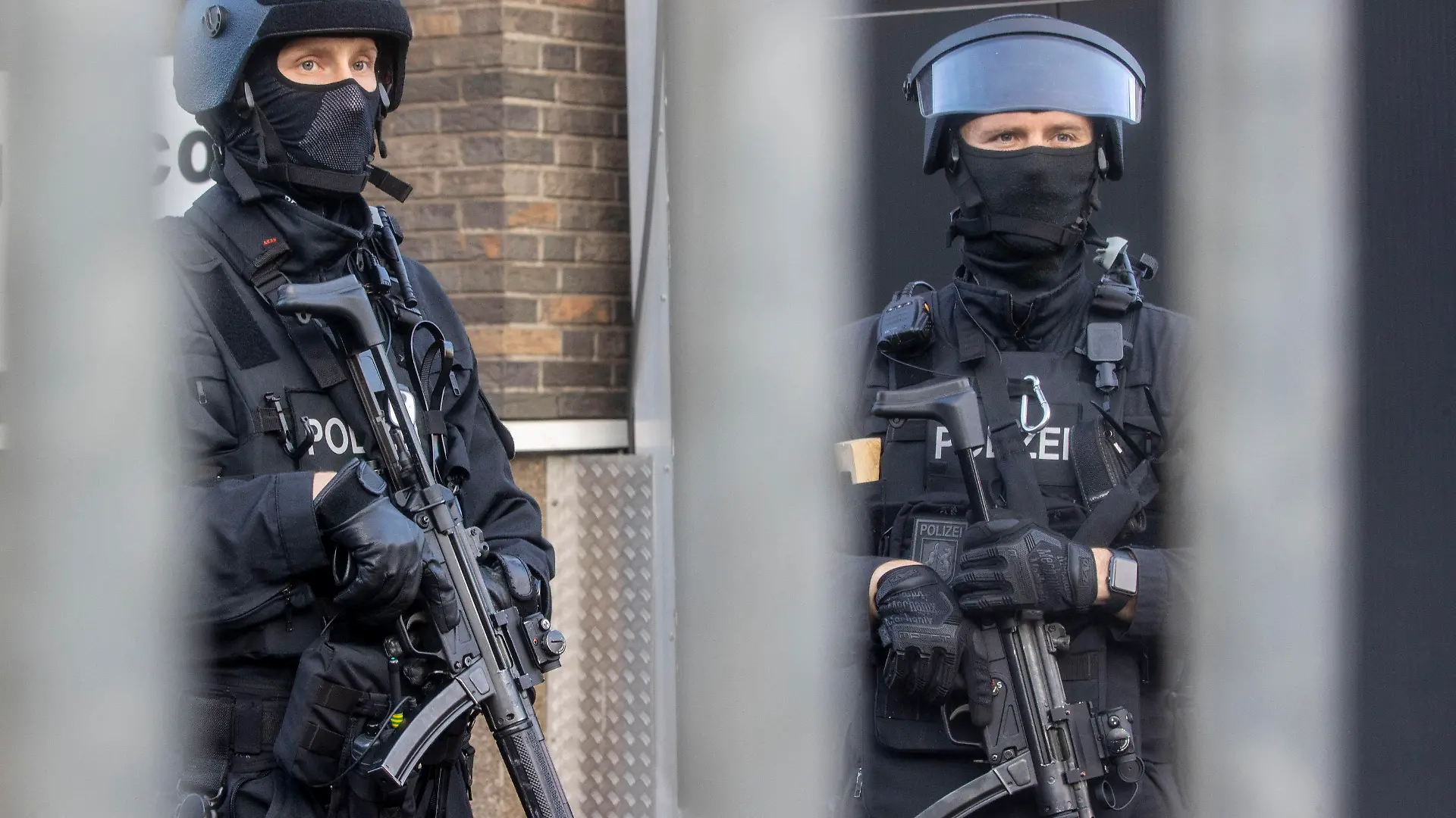 02.09.2021, Nordrhein-Westfalen, Duisburg: Polizisten stehen vor einem abgesperrten Gebäude. Bei einer Razzia gegen Rockerkriminalität hat die Polizei am Donnerstagmorgen in mehreren Städten an Rhein und Ruhr mindestens 20 Gebäude durchsucht. Foto: Christoph Reichwein/dpa +++ dpa-Bildfunk +++
