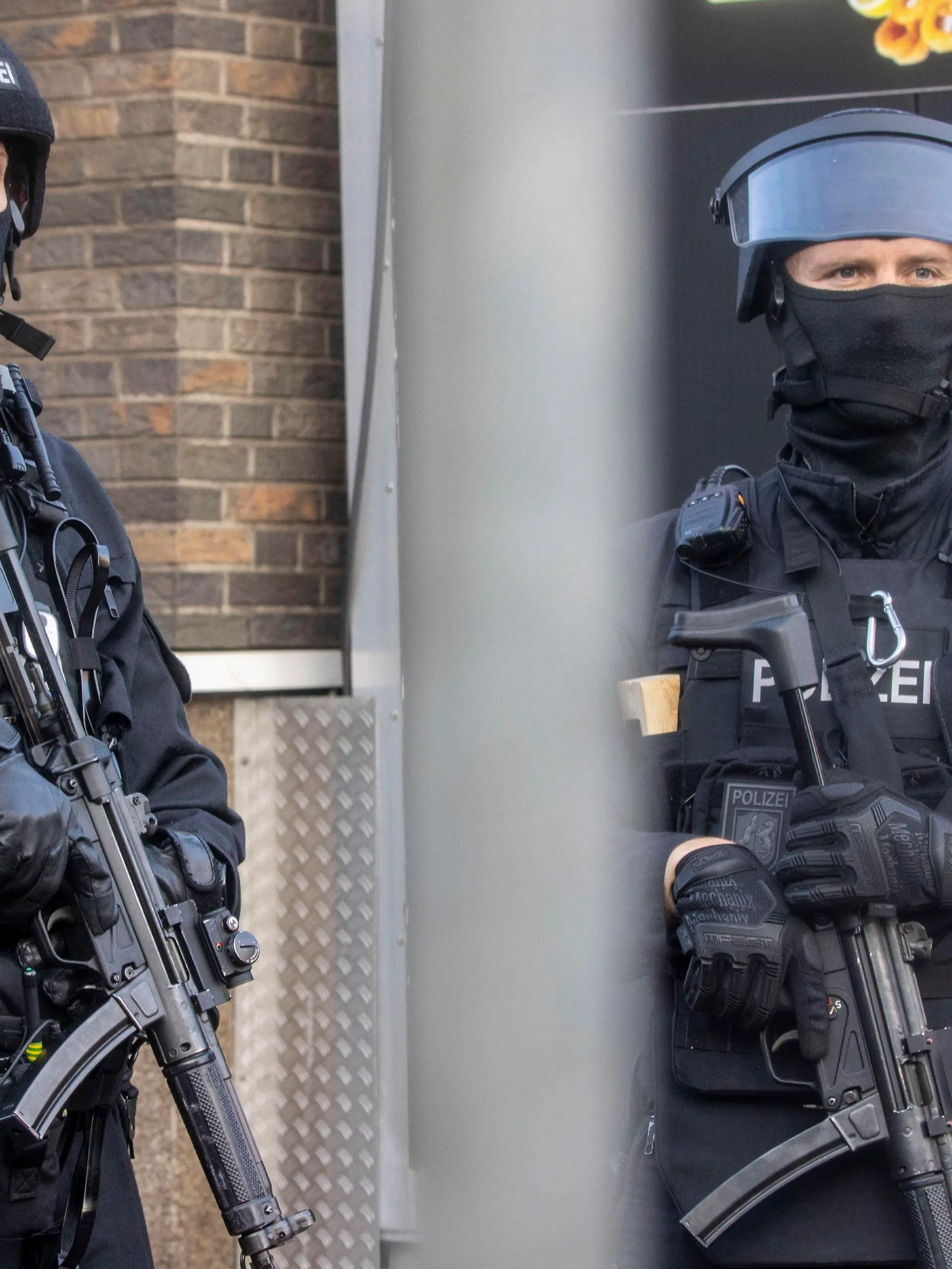 02.09.2021, Nordrhein-Westfalen, Duisburg: Polizisten stehen vor einem abgesperrten Gebäude. Bei einer Razzia gegen Rockerkriminalität hat die Polizei am Donnerstagmorgen in mehreren Städten an Rhein und Ruhr mindestens 20 Gebäude durchsucht. Foto: Christoph Reichwein/dpa +++ dpa-Bildfunk +++