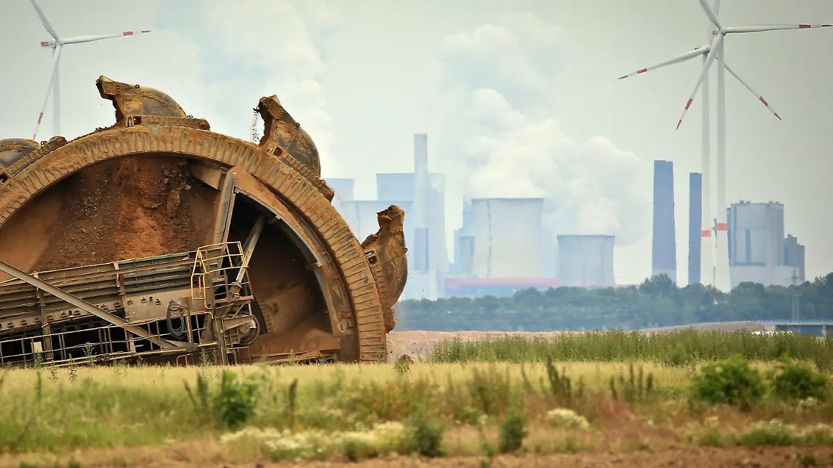 ARCHIV - 20.06.2019, Nordrhein-Westfalen, Jackerath: Der Schaufel eines Braunkohlebaggers baggert im Tagebau Garzeiler; im Hintergrund stehen eines der RWE-Kraftwerke und daneben Windräder. (zu dpa Themenpaket Weltklimakonferenz COP26 in Glasgow) Foto: David Young/dpa +++ dpa-Bildfunk +++