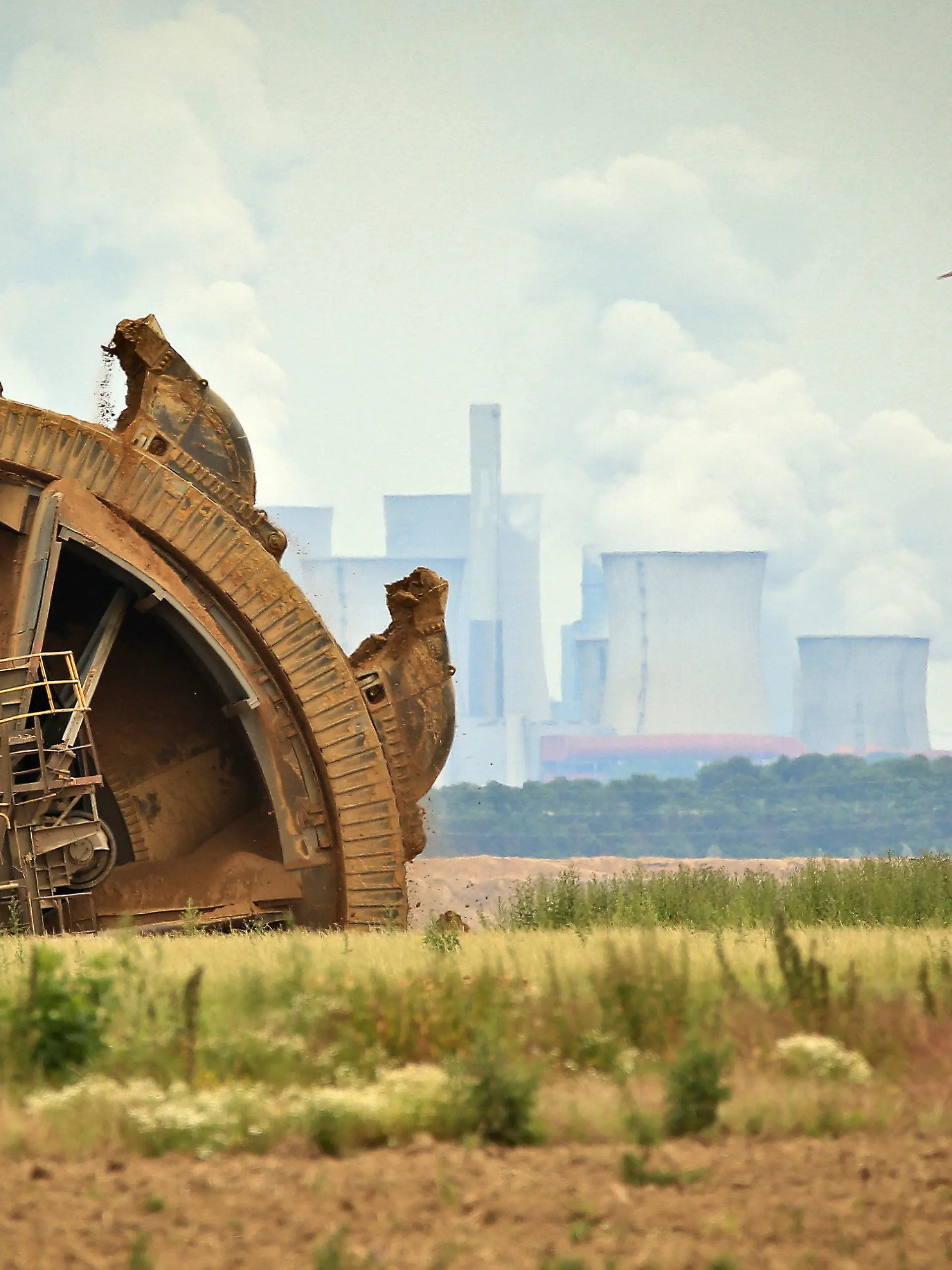 ARCHIV - 20.06.2019, Nordrhein-Westfalen, Jackerath: Der Schaufel eines Braunkohlebaggers baggert im Tagebau Garzeiler; im Hintergrund stehen eines der RWE-Kraftwerke und daneben Windräder. (zu dpa Themenpaket Weltklimakonferenz COP26 in Glasgow) Foto: David Young/dpa +++ dpa-Bildfunk +++