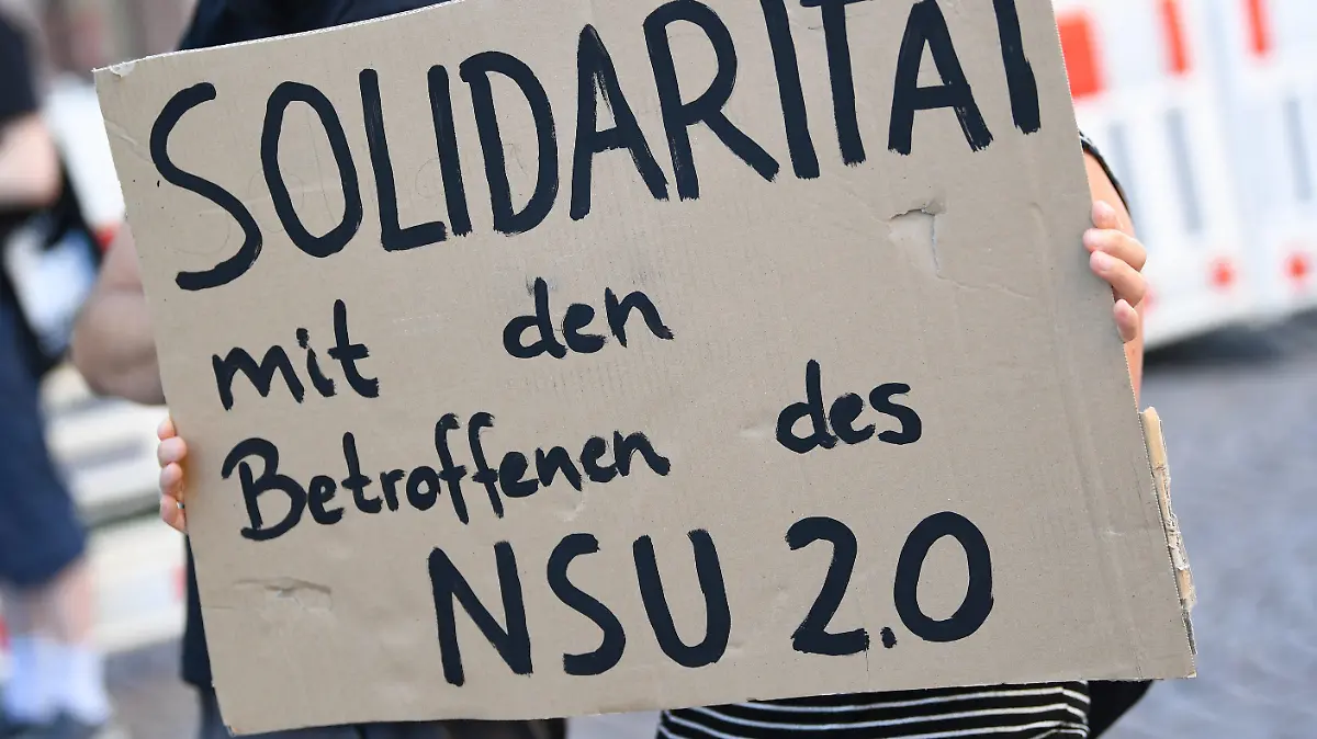 ARCHIV - 21.07.2020, Hessen, Wiesbaden: Ein Demonstrantin hält während einer Kundgebung in der Wiesbadener Innenstadt ein Plakat mit der Aufschrift «Solidarität mit den Betroffenen des NSU 2.0». Ein mutmaßlicher Verfasser von rechtsextremen Drohschreiben mit dem Absender «NSU 2.0» ist in Berlin bei einer Wohnungsdurchsuchung festgenommen worden. Foto: Arne Dedert/dpa +++ dpa-Bildfunk +++