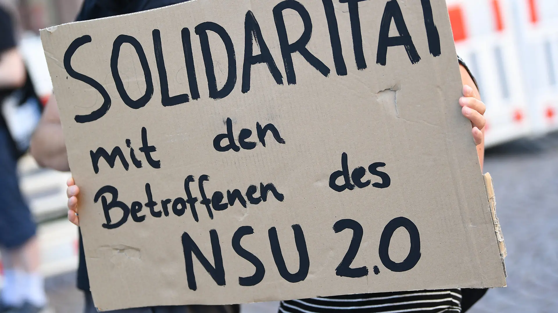 ARCHIV - 21.07.2020, Hessen, Wiesbaden: Ein Demonstrantin hält während einer Kundgebung in der Wiesbadener Innenstadt ein Plakat mit der Aufschrift «Solidarität mit den Betroffenen des NSU 2.0». Ein mutmaßlicher Verfasser von rechtsextremen Drohschreiben mit dem Absender «NSU 2.0» ist in Berlin bei einer Wohnungsdurchsuchung festgenommen worden. Foto: Arne Dedert/dpa +++ dpa-Bildfunk +++