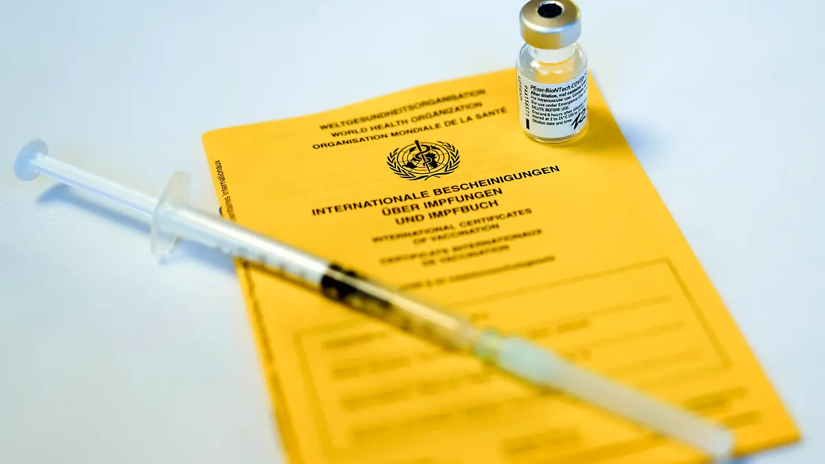 Impfstart in Koeln erste Bewohner von Pflegeheimen werden geimpft Symbolbild, Symbolfoto Impfpass mit einer Ampulle von Biontech Pfizer Impfstoff und Spritze wahrend der ersten Impfung in Pflegeheimen Koeln Nordrhein-Westfalen Deutschland *** Vaccination start in Cologne first residents of nursing homes are vaccinated symbol picture, symbol photo vaccination passport with an ampoule of Biontech Pfizer vaccine and syringe during the first vaccination in nursing homes Cologne North Rhine Westphalia Germany