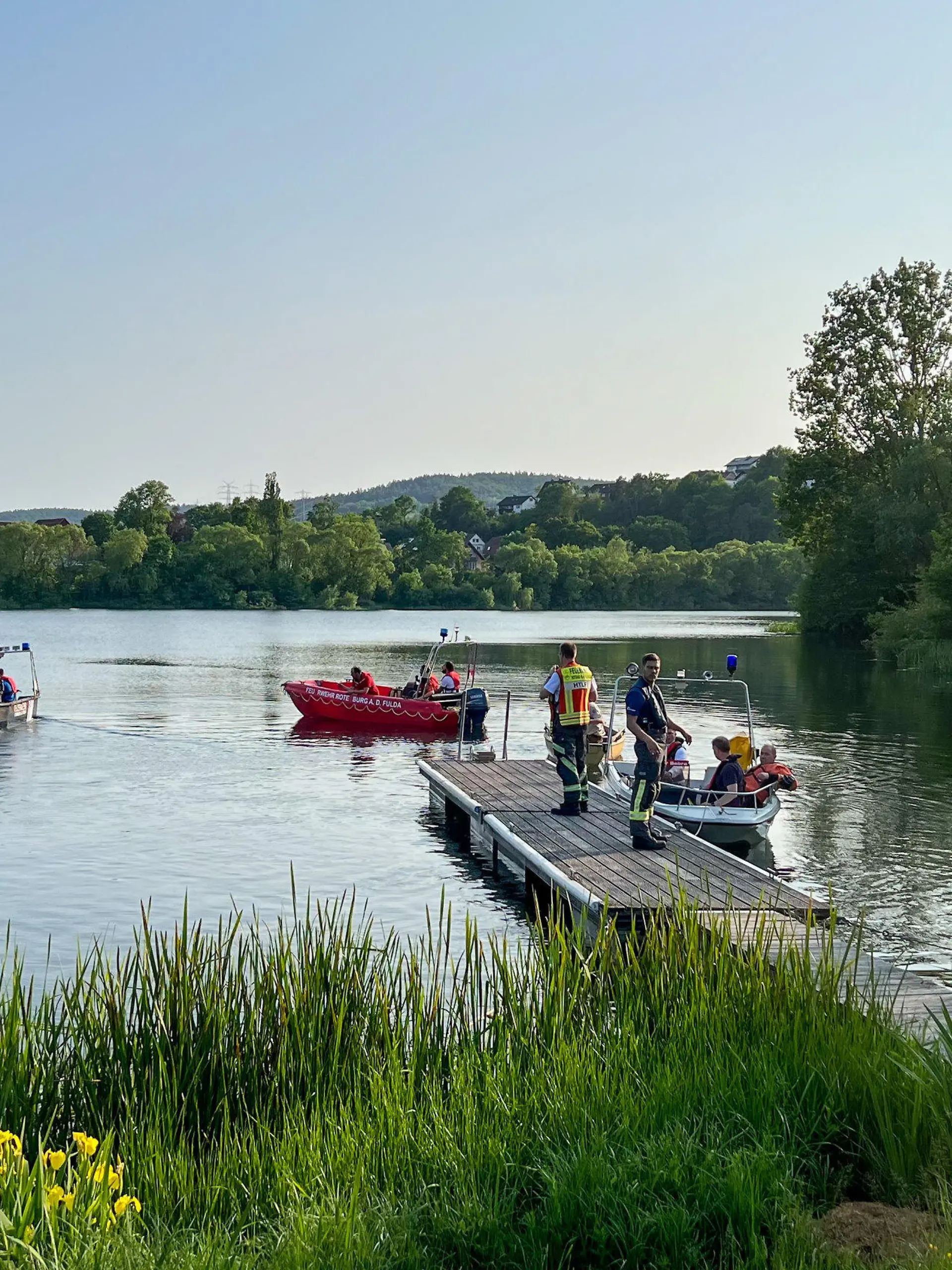 27.05.2023, Hessen, Bebra: Feuerwehr und Rettungsdienste suchern am Breitenbacher See nach zwei vermissten Jugendlichen. Zwei Jugendliche sind am Samstag in einem hessischen Badesee ertrunken. Wie die Polizei mitteilte, waren mehrere Jugendliche am Nachmittag auf einem Boot auf dem Breitenbacher See nahe Bebra unterwegs. Ein 13-Jähriger und eine 15-Jährige gingen ins Wasser und aus zunächst unklarer Ursache unter. Foto: Yuliya Krannich/TVNews-Hessen/dpa +++ dpa-Bildfunk +++