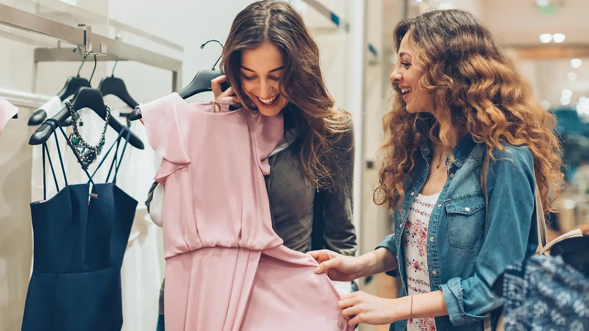 Two young women choosing dresses in a luxury fashion store