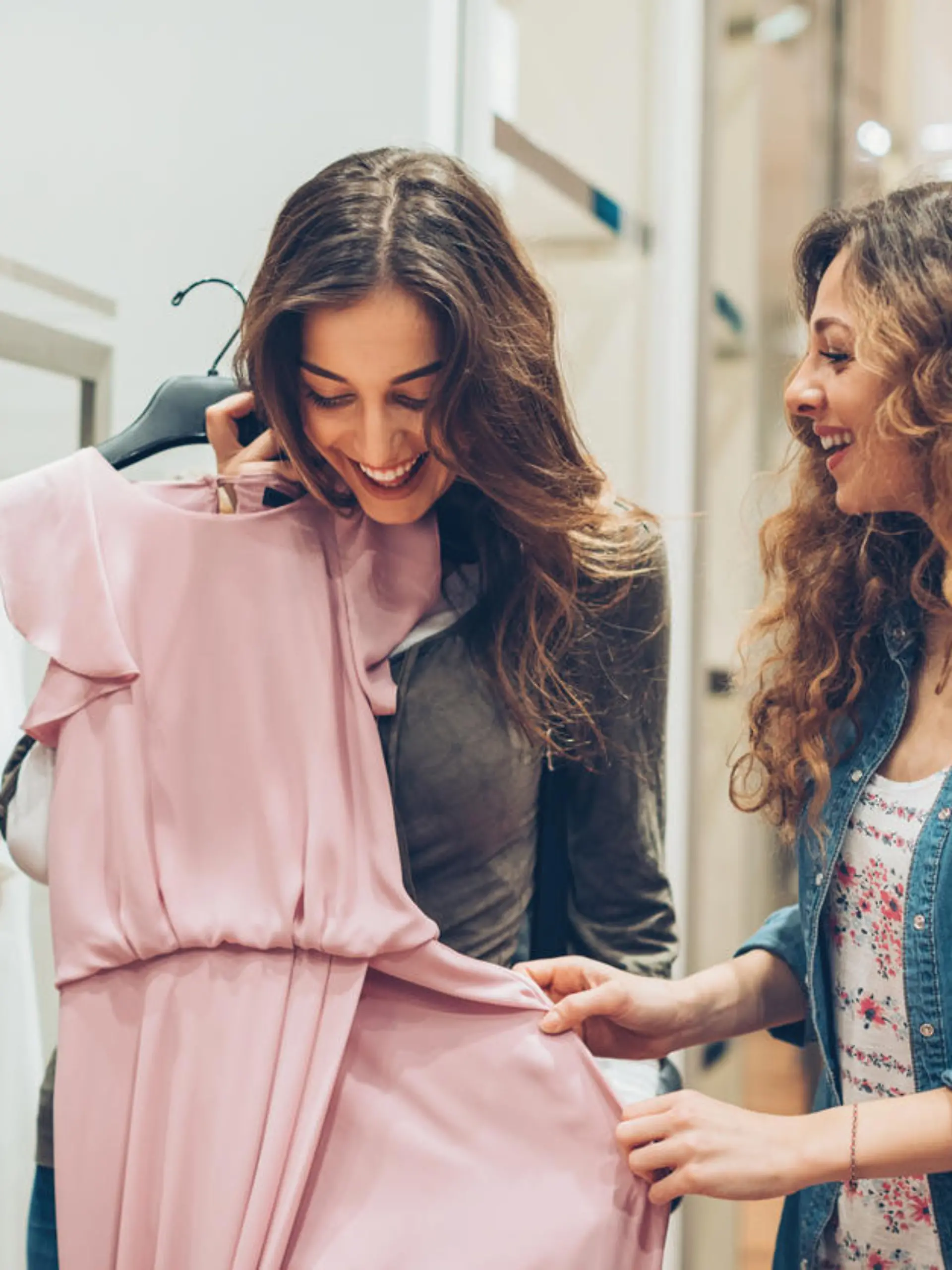 Two young women choosing dresses in a luxury fashion store