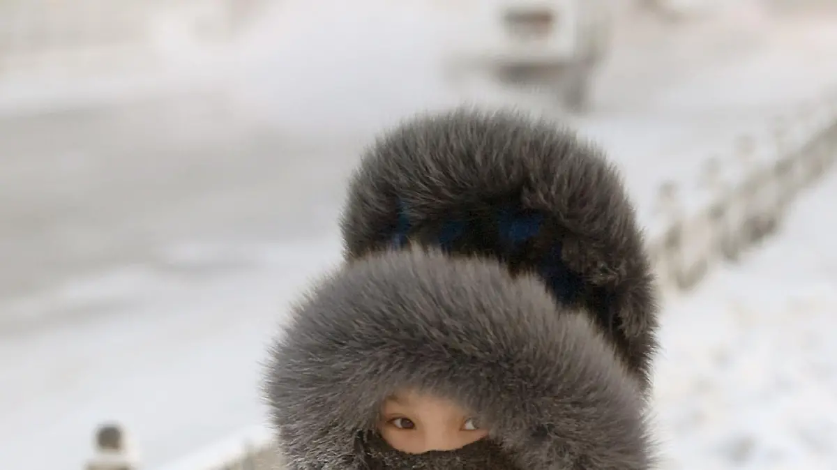 Ein Schulkind hat sich zum Schutz gegen die extreme Kälte in Jakutsk eine wärmende Kopfbedeckung aufgesetzt (Aufnahme vom 26.11.2007). Minus 20 Grad in Wladiwostok, minus 38 Grad am Baikalsee, sogar minus 46 Grad in Jakutsk zeigen die Thermometer in diesen Tagen. Doch bedarf es nicht erst klirrender Kälte, dass die Menschen beiderseits des Ural ihre mächtigen Pelzmützen und dichten Wollkappen aus dem Schrank holen. Schon ab den ersten kühlen Tagen des Winters gilt eine Kopfbedeckung als Muss. Schließlich lernen russische Kinder bereits früh, dass der Körper rund zwei Drittel seiner Wärmeenergie über Gesicht und Hals verliert. Foto: Björn Steinz (Zu dpa-Korr.: "Die Mütze der Garbo: Wie sich die Russen vor Rekordkälte schützen" vom 18.01.2008) +++(c) dpa - Bildfunk+++