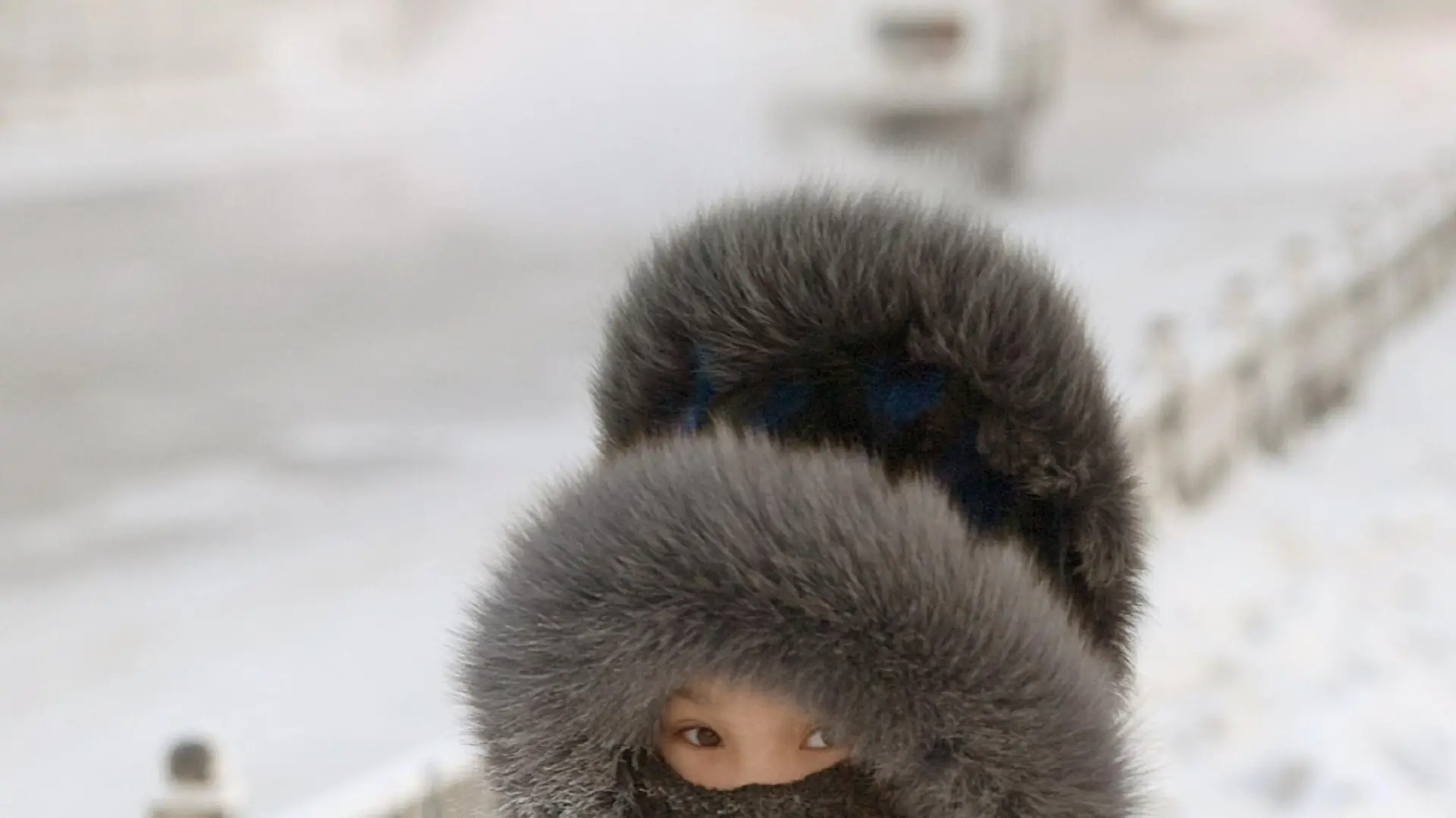 Ein Schulkind hat sich zum Schutz gegen die extreme Kälte in Jakutsk eine wärmende Kopfbedeckung aufgesetzt (Aufnahme vom 26.11.2007). Minus 20 Grad in Wladiwostok, minus 38 Grad am Baikalsee, sogar minus 46 Grad in Jakutsk zeigen die Thermometer in diesen Tagen. Doch bedarf es nicht erst klirrender Kälte, dass die Menschen beiderseits des Ural ihre mächtigen Pelzmützen und dichten Wollkappen aus dem Schrank holen. Schon ab den ersten kühlen Tagen des Winters gilt eine Kopfbedeckung als Muss. Schließlich lernen russische Kinder bereits früh, dass der Körper rund zwei Drittel seiner Wärmeenergie über Gesicht und Hals verliert. Foto: Björn Steinz (Zu dpa-Korr.: "Die Mütze der Garbo: Wie sich die Russen vor Rekordkälte schützen" vom 18.01.2008) +++(c) dpa - Bildfunk+++