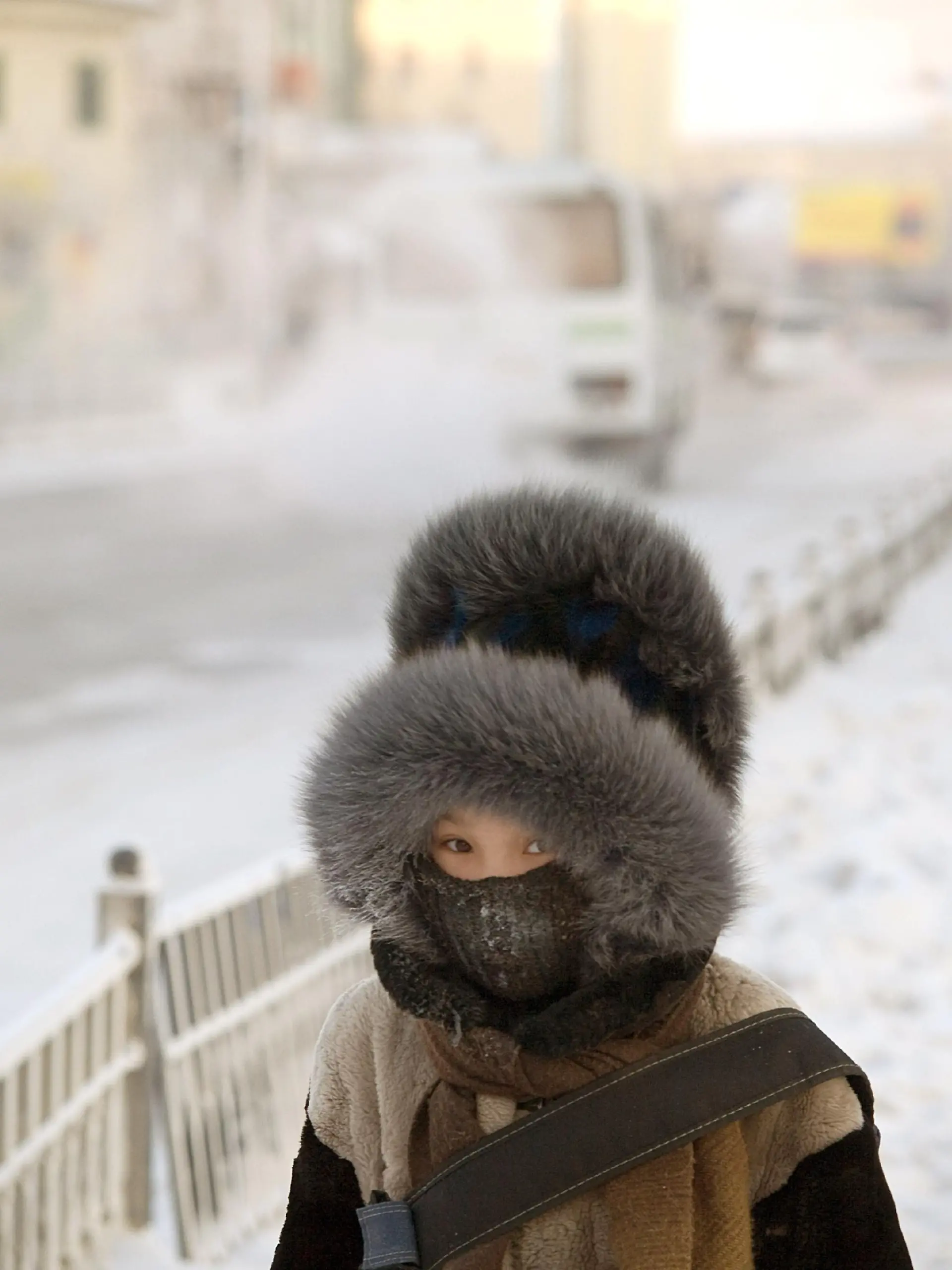 Ein Schulkind hat sich zum Schutz gegen die extreme Kälte in Jakutsk eine wärmende Kopfbedeckung aufgesetzt (Aufnahme vom 26.11.2007). Minus 20 Grad in Wladiwostok, minus 38 Grad am Baikalsee, sogar minus 46 Grad in Jakutsk zeigen die Thermometer in diesen Tagen. Doch bedarf es nicht erst klirrender Kälte, dass die Menschen beiderseits des Ural ihre mächtigen Pelzmützen und dichten Wollkappen aus dem Schrank holen. Schon ab den ersten kühlen Tagen des Winters gilt eine Kopfbedeckung als Muss. Schließlich lernen russische Kinder bereits früh, dass der Körper rund zwei Drittel seiner Wärmeenergie über Gesicht und Hals verliert. Foto: Björn Steinz (Zu dpa-Korr.: "Die Mütze der Garbo: Wie sich die Russen vor Rekordkälte schützen" vom 18.01.2008) +++(c) dpa - Bildfunk+++