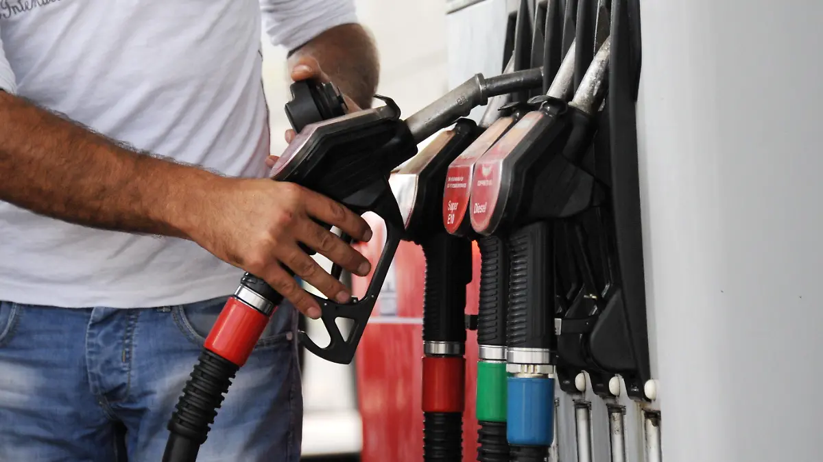 ARCHIV - Ein Mann greift am 31.08.2013 in München (Bayern) nach einer Zapfpistole an einer Tankstelle. Foto: Tobias Hase/dpa (zu dpa «Preiswerter Hochsommer: Diesel, Benzin und Heizöl wieder billiger» vom 14.08.2016) +++(c) dpa - Bildfunk+++