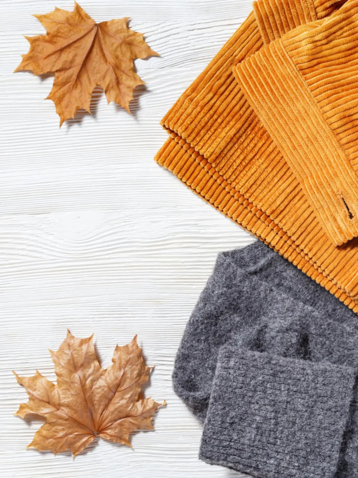 Female autumn clothing, warm wool grey knitted jumper and orange trousers from corduroy. Shopping overview concept with copy space. Top view. Flat lay.