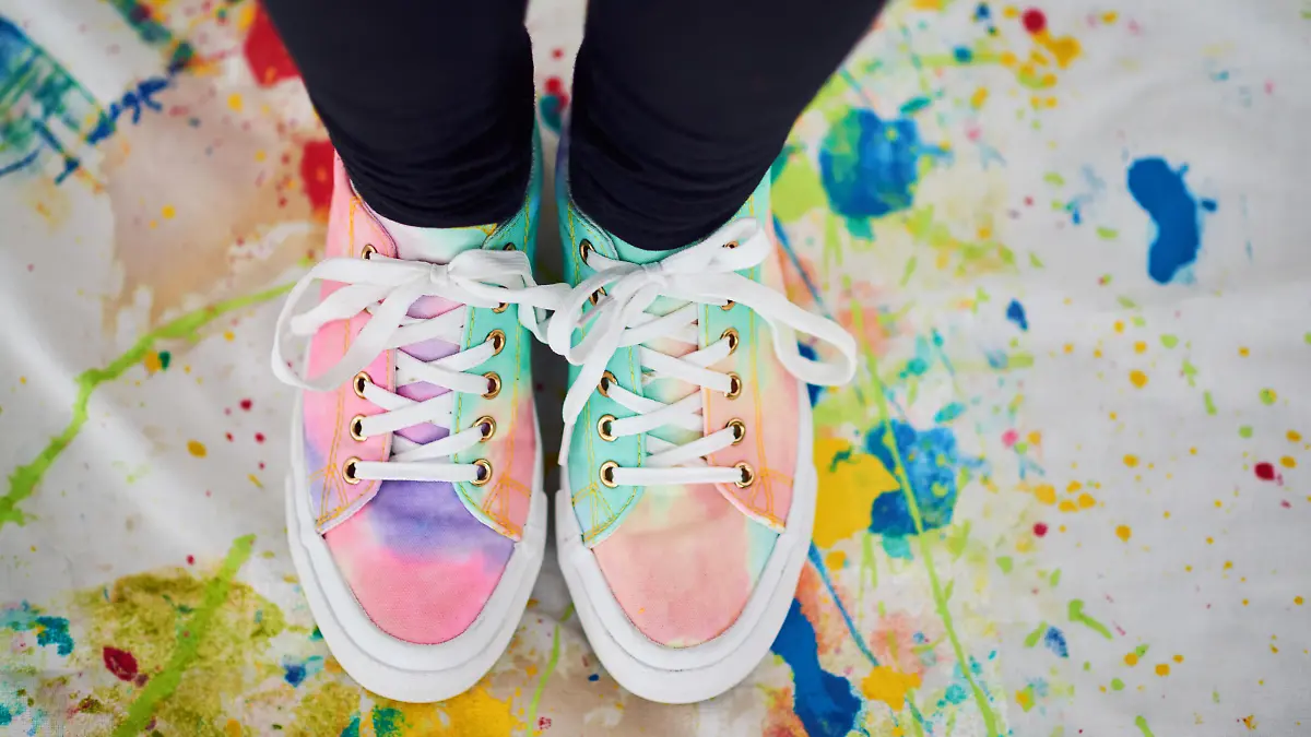 Cropped shot of an unrecognizable woman standing with colorful shoes on a painted cloth