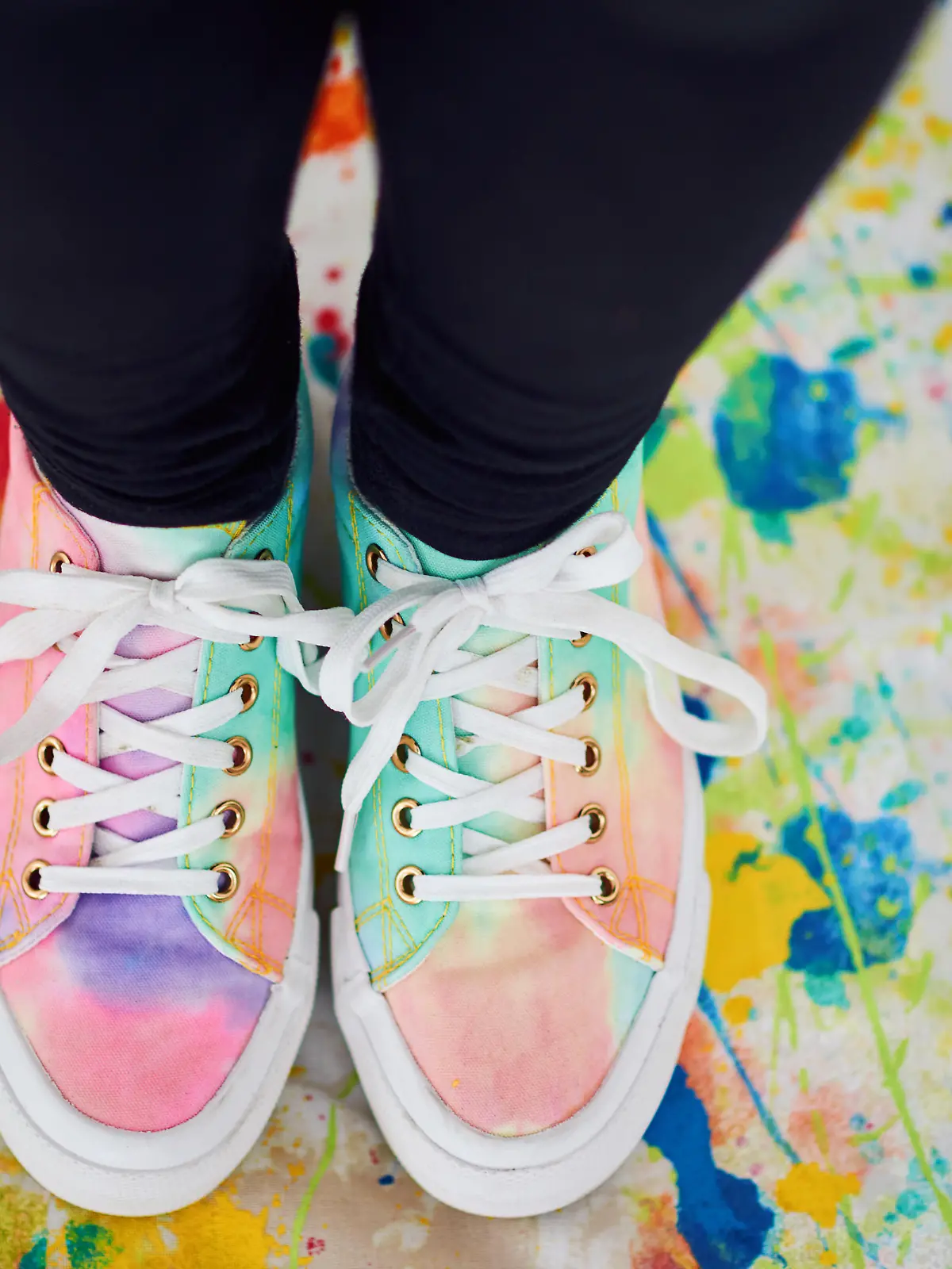 Cropped shot of an unrecognizable woman standing with colorful shoes on a painted cloth