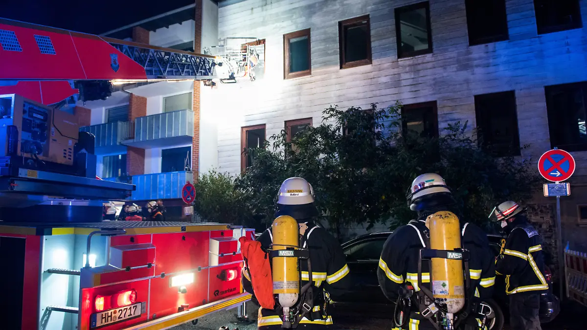 27.10.2021, Hamburg: Einsatzkräfte der Feuerwehr stehen im Stadtteil Billstedt vor einer Jugendwohneinrichtung. Bei einem Brand in dem Gebäude sind in der Nacht mehrere Bewohner verletzt worden. Foto: Daniel Bockwoldt/dpa +++ dpa-Bildfunk +++