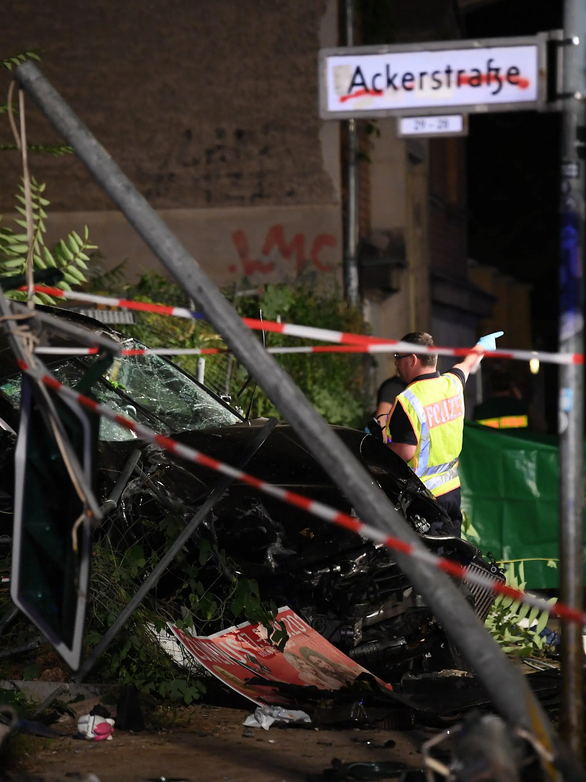 ARCHIV - 06.09.2019, Berlin: An einem zerstörten Auto halten Polizisten ein Plane. In Berlin-Mitte sind bei dem schweren Verkehrsunfall vier Menschen getötet worden. Ein Auto war an der Ecke Invalidenstraße und Ackerstraße auf einen Gehweg gefahren. (zu dpa «Fahrer kommt nach SUV-Unfall mit vier Toten vor Gericht») Foto: Britta Pedersen/dpa +++ dpa-Bildfunk +++