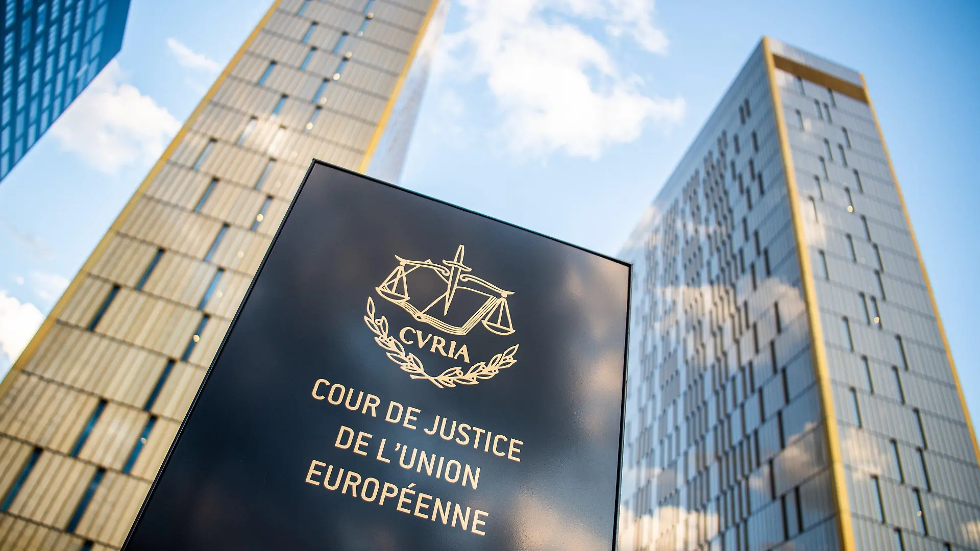 ARCHIV - 15.06.2019, Luxemburg: Ein Schild mit der Aufschrift «Cour de Justice de l'union Européene» steht vor den Bürotürmen des Europäischen Gerichtshofs im Europaviertel auf dem Kirchberg. (zu dpa "EuGH verurteilt Polen zur Zahlung von Zwangsgeld") Foto: Arne Immanuel Bänsch/dpa +++ dpa-Bildfunk +++