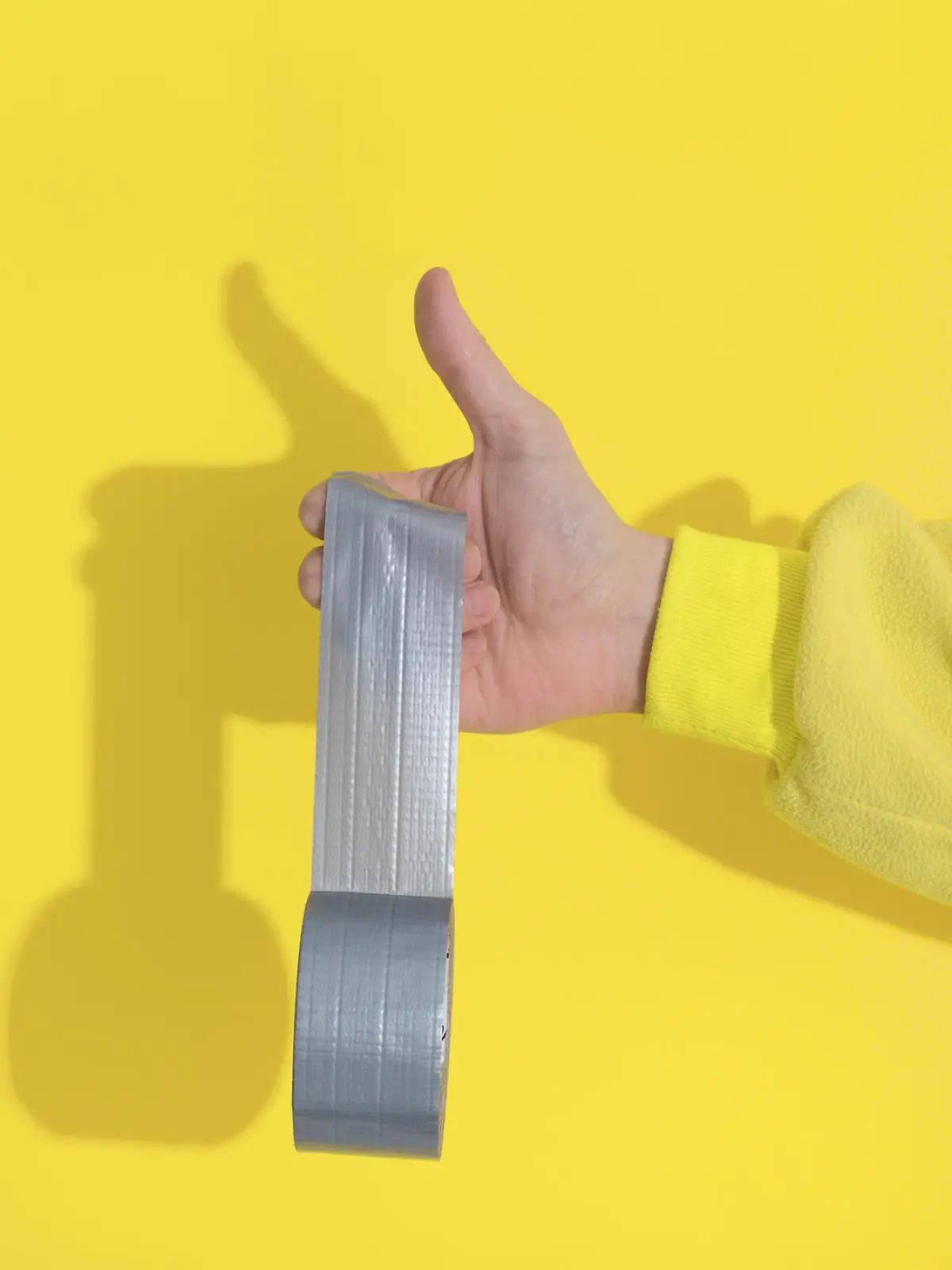 Male hand in yellow kugurumi holds Ultimate Gray  tape sticks