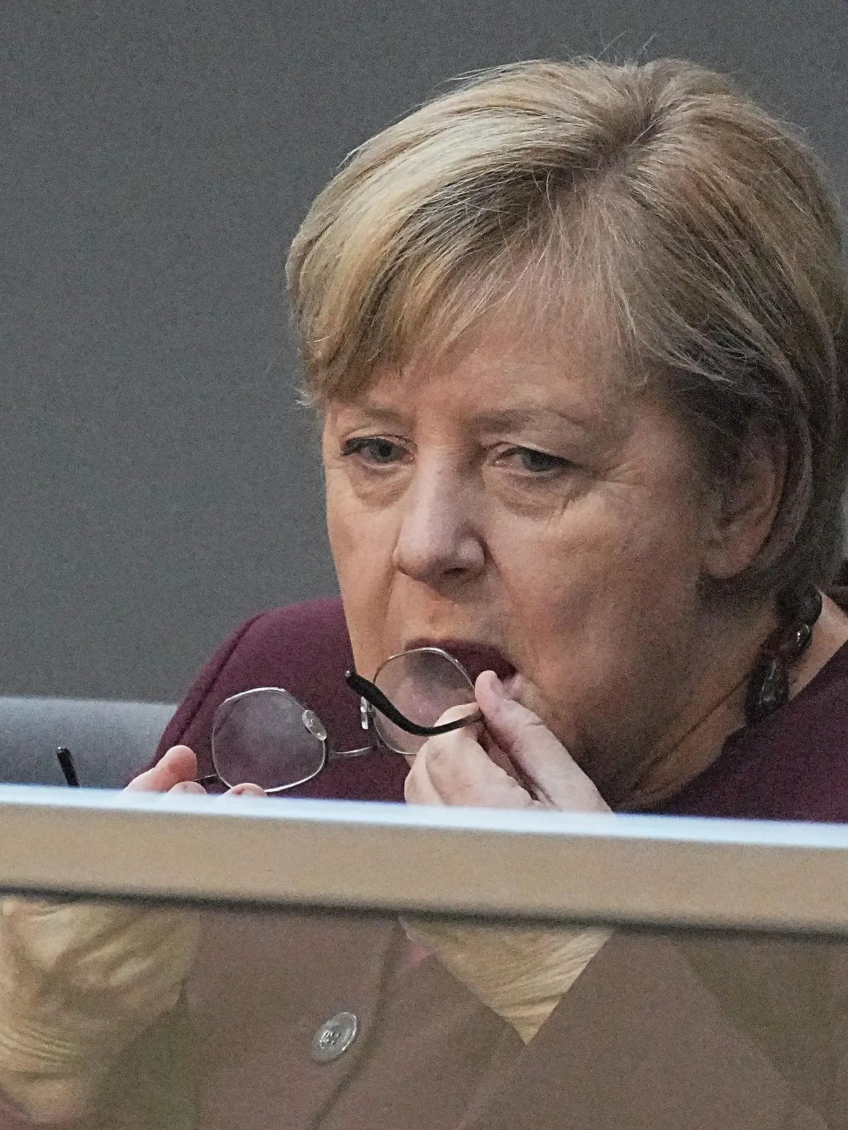Bundeskanzlerin Angela Merkel (CDU) sitzt auf der Ehrentribüne im Bundestag und putzt ihre Brille bei der konstituierenden Sitzung des neuen Bundestags.