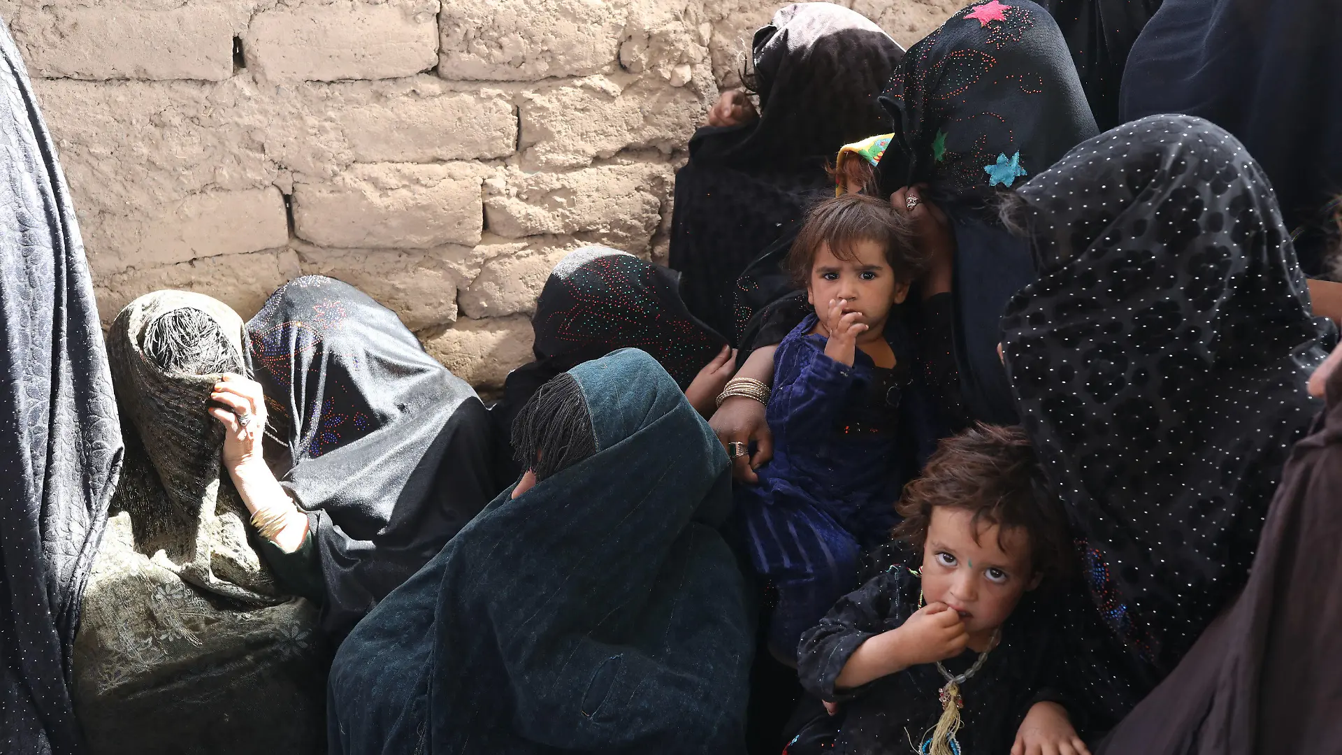 HANDOUT - 02.10.2021, Afghanistan, Herat: Mütter und Kinder warten in einer vom Welternährungsprogramm WFP und UNICEF betriebenen Ernährungsklinik in der Nähe eines Vertriebenenlagers am Stadtrand. (zu dpa "Hälfte der afghanischen Bevölkerung von akutem Hunger bedroht") Foto: Marco Di Lauro/World Food Programm WFP/dpa - ACHTUNG: Nur zur redaktionellen Verwendung im Zusammenhang mit der aktuellen Berichterstattung und nur mit vollständiger Nennung des vorstehenden Credits +++ dpa-Bildfunk +++