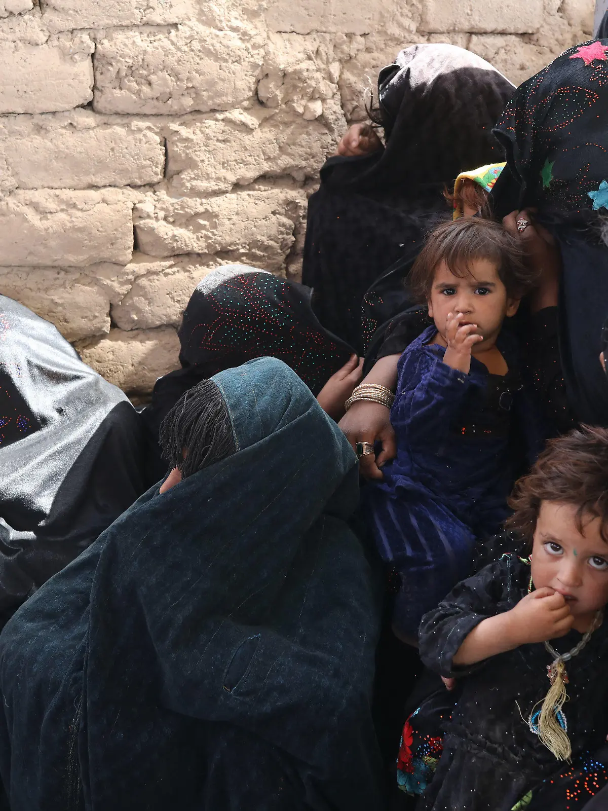 HANDOUT - 02.10.2021, Afghanistan, Herat: Mütter und Kinder warten in einer vom Welternährungsprogramm WFP und UNICEF betriebenen Ernährungsklinik in der Nähe eines Vertriebenenlagers am Stadtrand.       (zu dpa "Hälfte der afghanischen Bevölkerung von akutem Hunger bedroht") Foto: Marco Di Lauro/World Food Programm WFP/dpa - ACHTUNG: Nur zur redaktionellen Verwendung im Zusammenhang mit der aktuellen Berichterstattung und nur mit vollständiger Nennung des vorstehenden Credits +++ dpa-Bildfunk +++