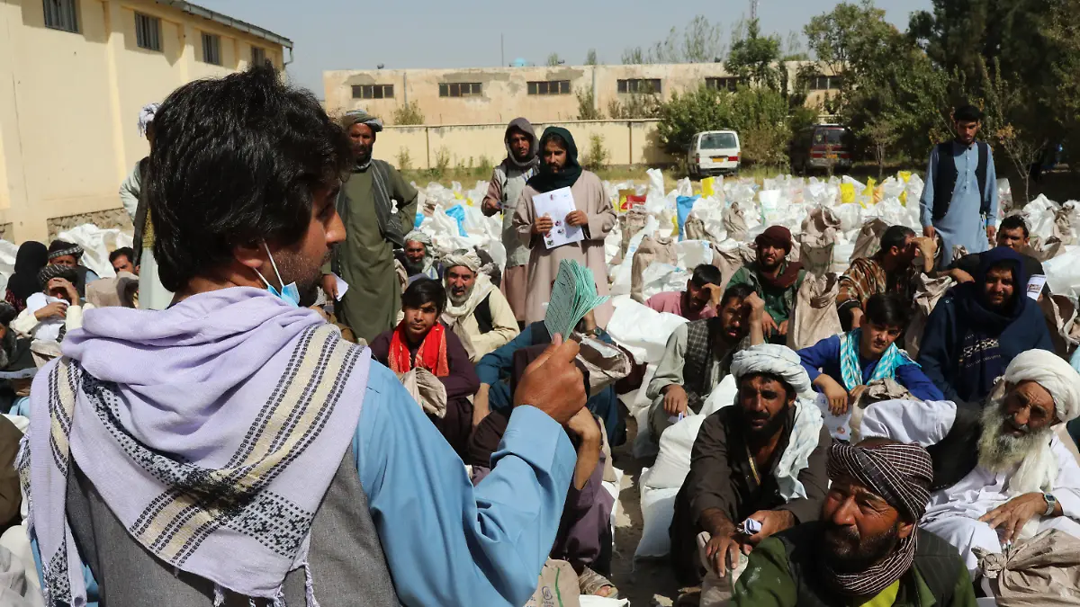HANDOUT - 02.10.2021, Afghanistan, Herat: Ein Mitarbeiter eines Partners des Welternährungsprogramms WFP verteilt Nahrungsmitteln am Stadtrand. Die Rationen bestehen aus Weizenmehl, Erbsen, Öl und Salz für jede Familie.        (zu dpa "Hälfte der afghanischen Bevölkerung von akutem Hunger bedroht") Foto: Marco Di Lauro/World Food Programm WFP/dpa - ACHTUNG: Nur zur redaktionellen Verwendung im Zusammenhang mit der aktuellen Berichterstattung und nur mit vollständiger Nennung des vorstehenden Credits +++ dpa-Bildfunk +++