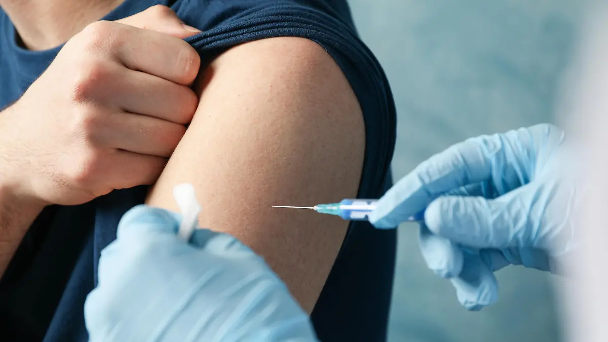 Doctor does an injection patient on blue background. Coronavirus protection. Healthcare and medical concept