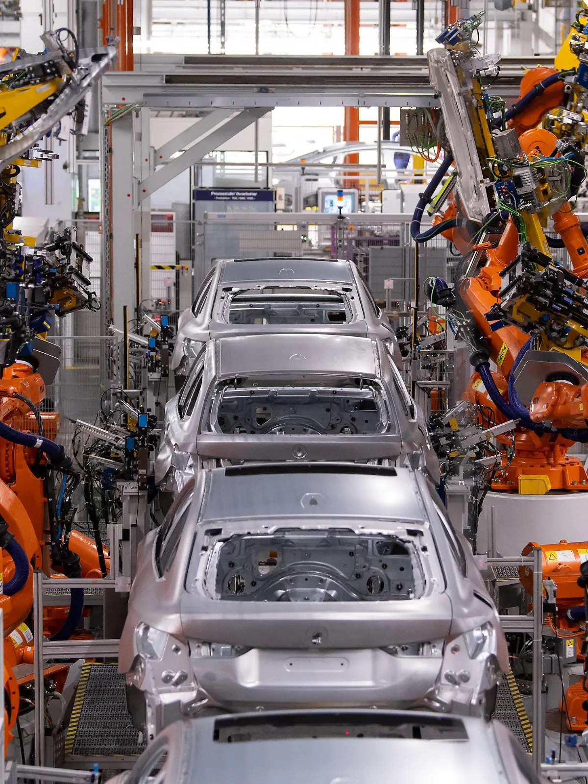22.10.2021, Bayern, München: Roboter arbeiten an der Karosserie von verschiedenen BMW-Modellen im Stammwerk. Drei Monate nach dem Elektro-SUV BMW iX hat der Autobauer jetzt auch die Serienproduktion des vollelektrischen BMW i4 gestartet. Im Stammwerk München lief am Freitag das erste Fahrzeug vom Band. Foto: Sven Hoppe/dpa +++ dpa-Bildfunk +++