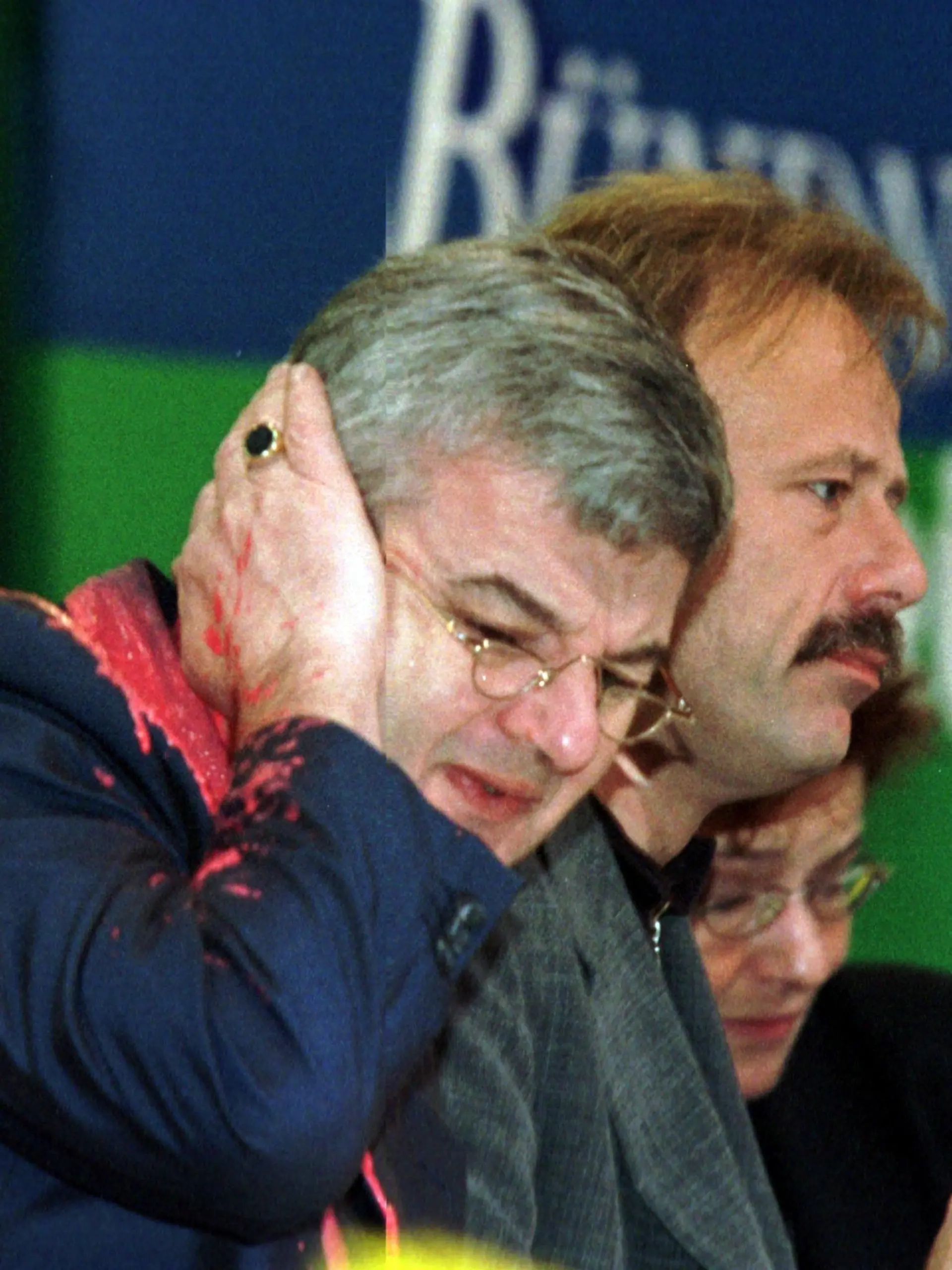 Von einem Farbbeutel getroffen, faßt sich Bundesaußenminister Joschka Fischer am 13.5.1999 auf dem Sonderparteitag der Grünen in Bielefeld erschrocken ans Ohr, rechts sitzen Bundesumweltminister Jürgen Trittin und die verteidigungspoltische Sprecherin der Grünen, Angelika Beer. Fischer war von einem Demonstranten mit einem Farbbeutel beworfen worden und erlitt dabei leichte Risse im Trommelfell. Er ließ sich deswegen kurz in einem Krankenhaus behandeln. Der Unbekannte hatte Fischer als "Kriegshetzer" beschimmpft und den roten Farbbeutel auf den Minister geworfen, als er den Parteitag auf dem Präsidiums-Podium verfolgte. [dpabilderarchiv]