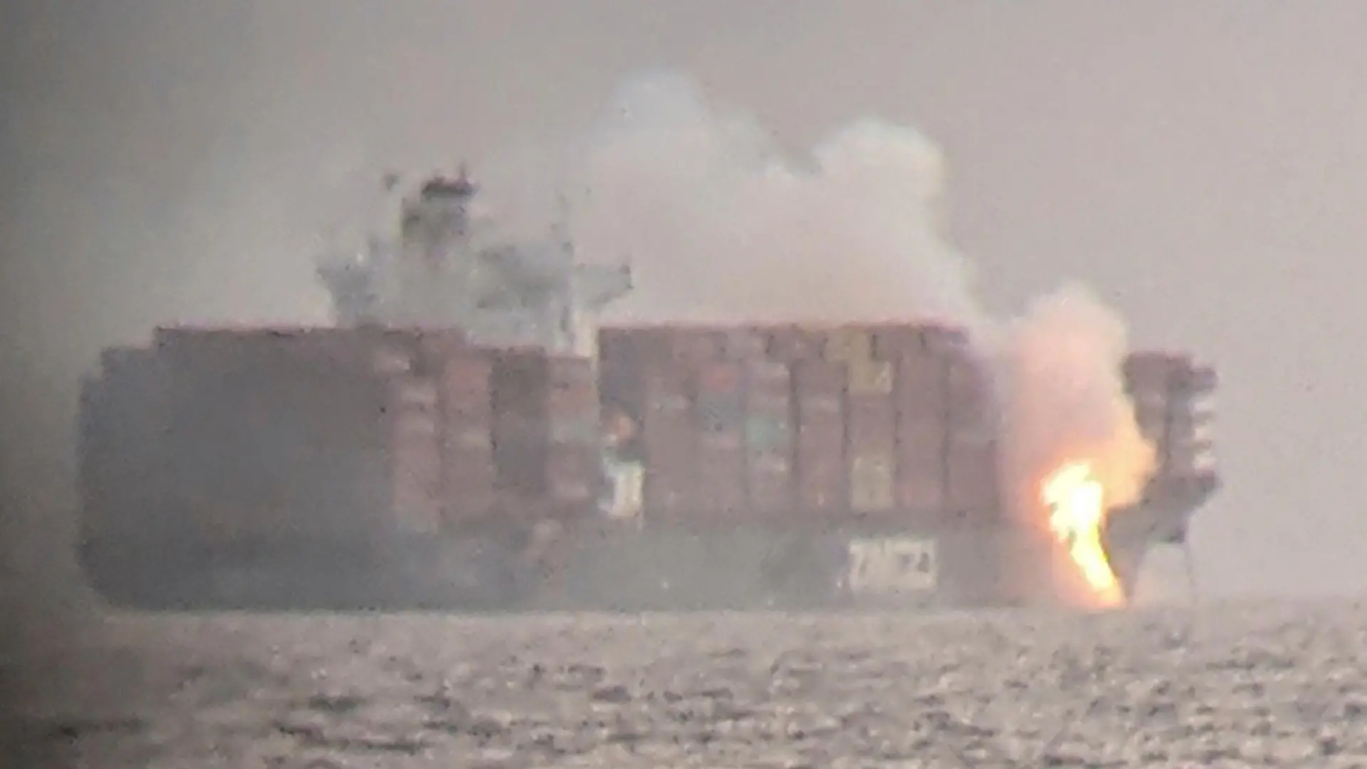 Fire cascades down from the deck of the container ship ZIM Kingston into the waters off the coast of Victoria, British Columbia, Canada, October 23, 2021, as seen through a pair of binoculars, in this image obtained via social media. SURFRIDER FOUNDATION CANADA via REUTERS ATTENTION EDITORS - THIS IMAGE HAS BEEN SUPPLIED BY A THIRD PARTY. MANDATORY CREDIT. NO RESALES. NO ARCHIVES. THIS PICTURE WAS PROCESSED BY REUTERS TO ENHANCE QUALITY. AN UNPROCESSED VERSION HAS BEEN PROVIDED SEPARATELY
