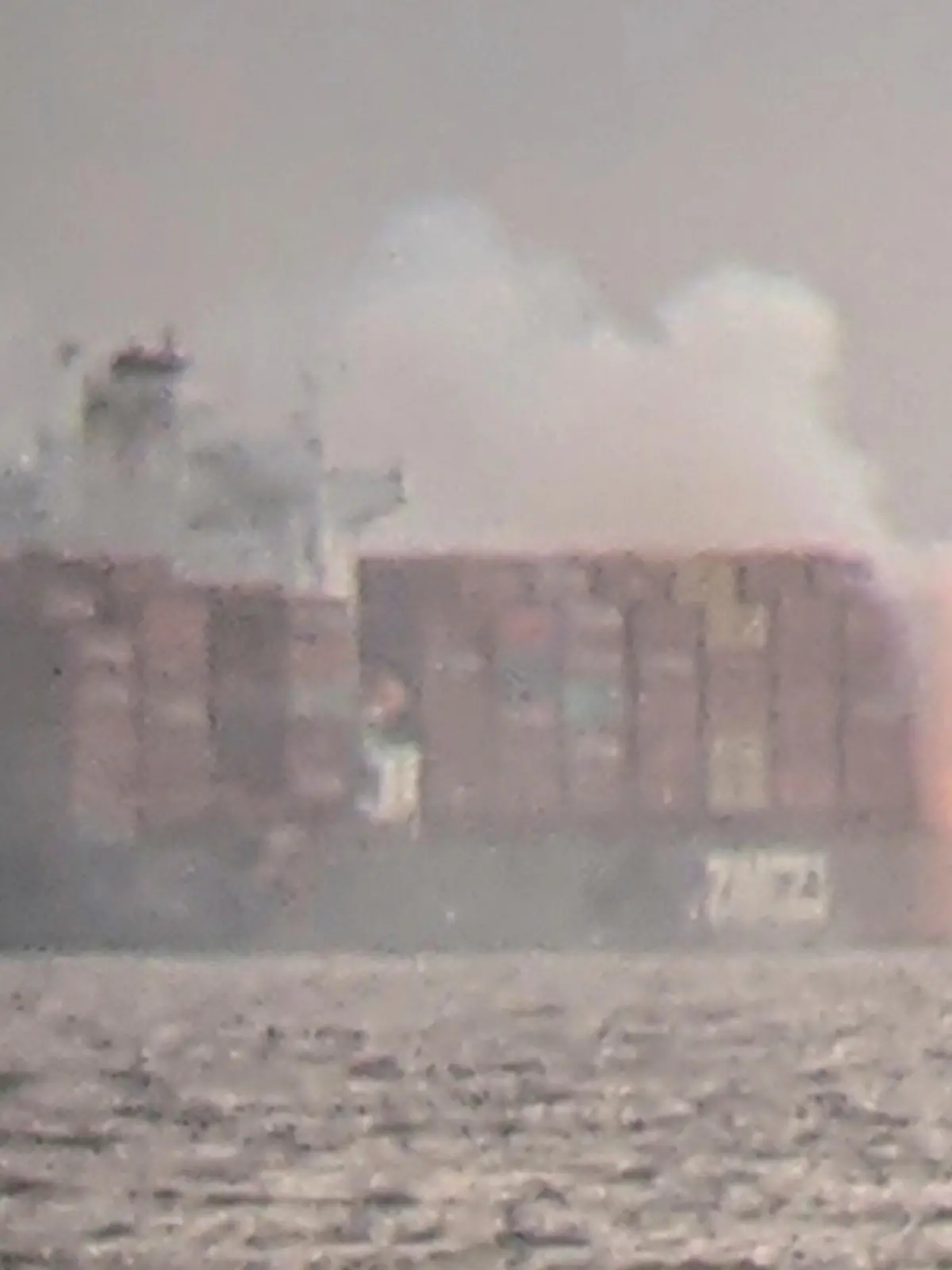 Fire cascades down from the deck of the container ship ZIM Kingston into the waters off the coast of Victoria, British Columbia, Canada, October 23, 2021, as seen through a pair of binoculars, in this image obtained via social media. SURFRIDER FOUNDATION CANADA via REUTERS   ATTENTION EDITORS - THIS IMAGE HAS BEEN SUPPLIED BY A THIRD PARTY. MANDATORY CREDIT. NO RESALES. NO ARCHIVES. THIS PICTURE WAS PROCESSED BY REUTERS TO ENHANCE QUALITY. AN UNPROCESSED VERSION HAS BEEN PROVIDED SEPARATELY