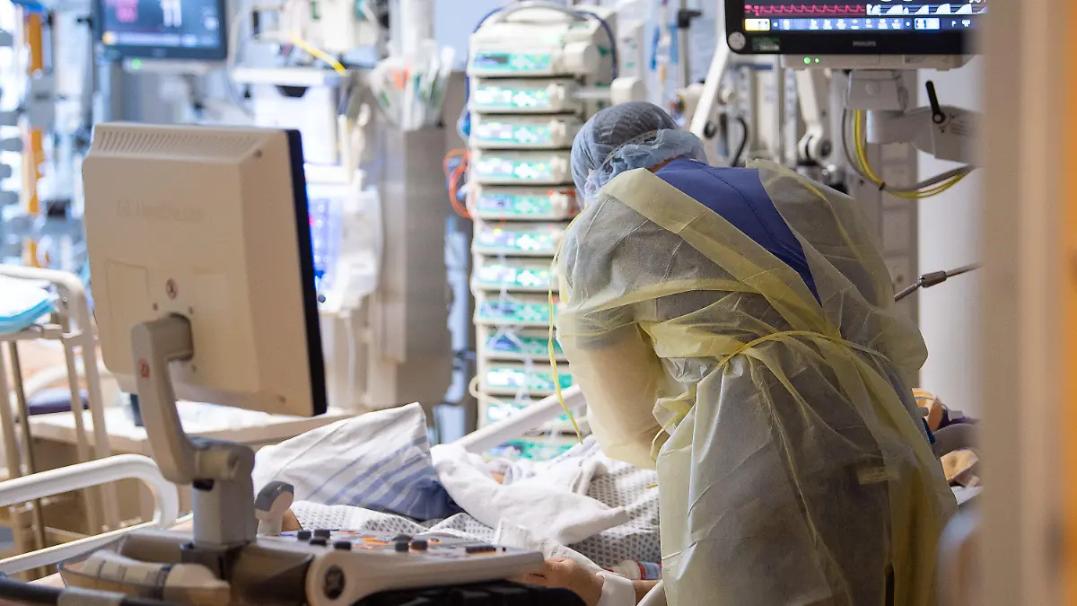 ARCHIV - 08.01.2021, Baden-Württemberg, Ludwigsburg: Ein Intensivpfleger arbeitet auf einer Intensivstation des RKH Klinikum Ludwigsburg an einem Covid-19-Patient. (zu dpa: "Corona-Experte: Belastungen der Intensivstationen bis 2022") Foto: Sebastian Gollnow/dpa +++ dpa-Bildfunk +++