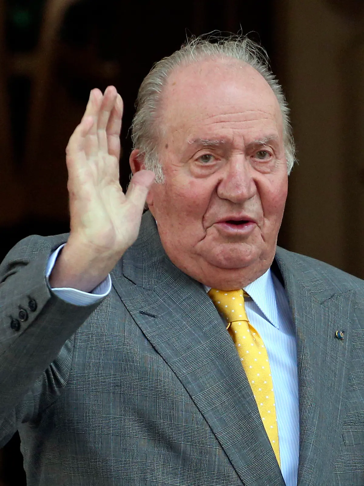 ARCHIV - 10.03.2018, Chile, Santiago: Juan Carlos, ehemaliger König von Spanien, winkt bei seiner Ankunft an der Academia Diplomatica von Chile. Carlos ist seit Freitagabend, 23.08.2019, wegen einer geplanten Operation am Herzen in einem Madrider Krankenhaus. Foto: Esteban Felix/AP/dpa +++ dpa-Bildfunk +++