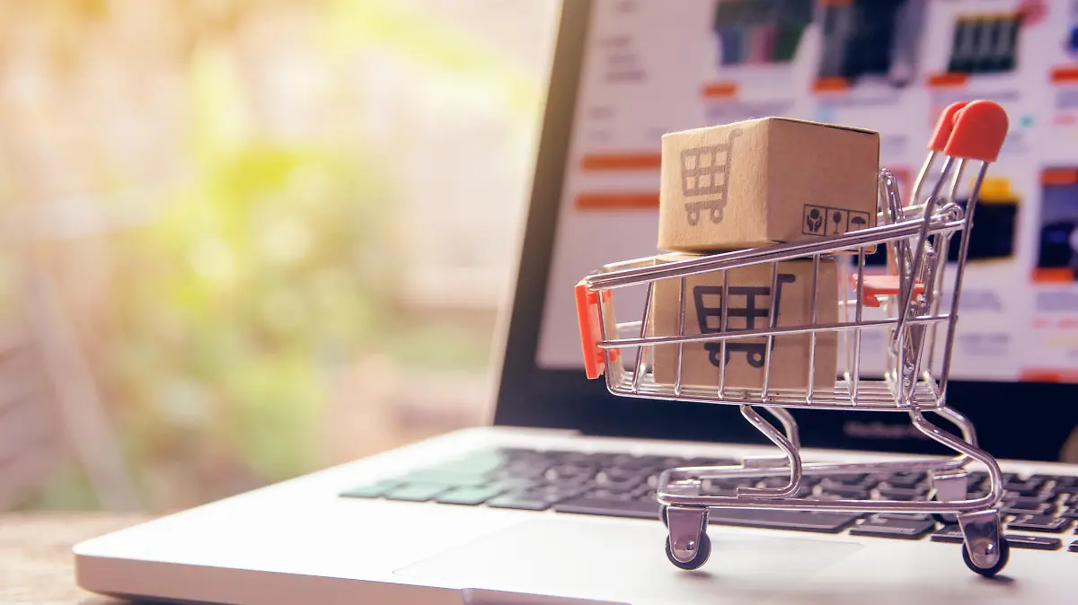 Shopping online concept - Parcel or Paper cartons with a shopping cart logo in a trolley on a laptop keyboard. Shopping service on The online web. offers home delivery.